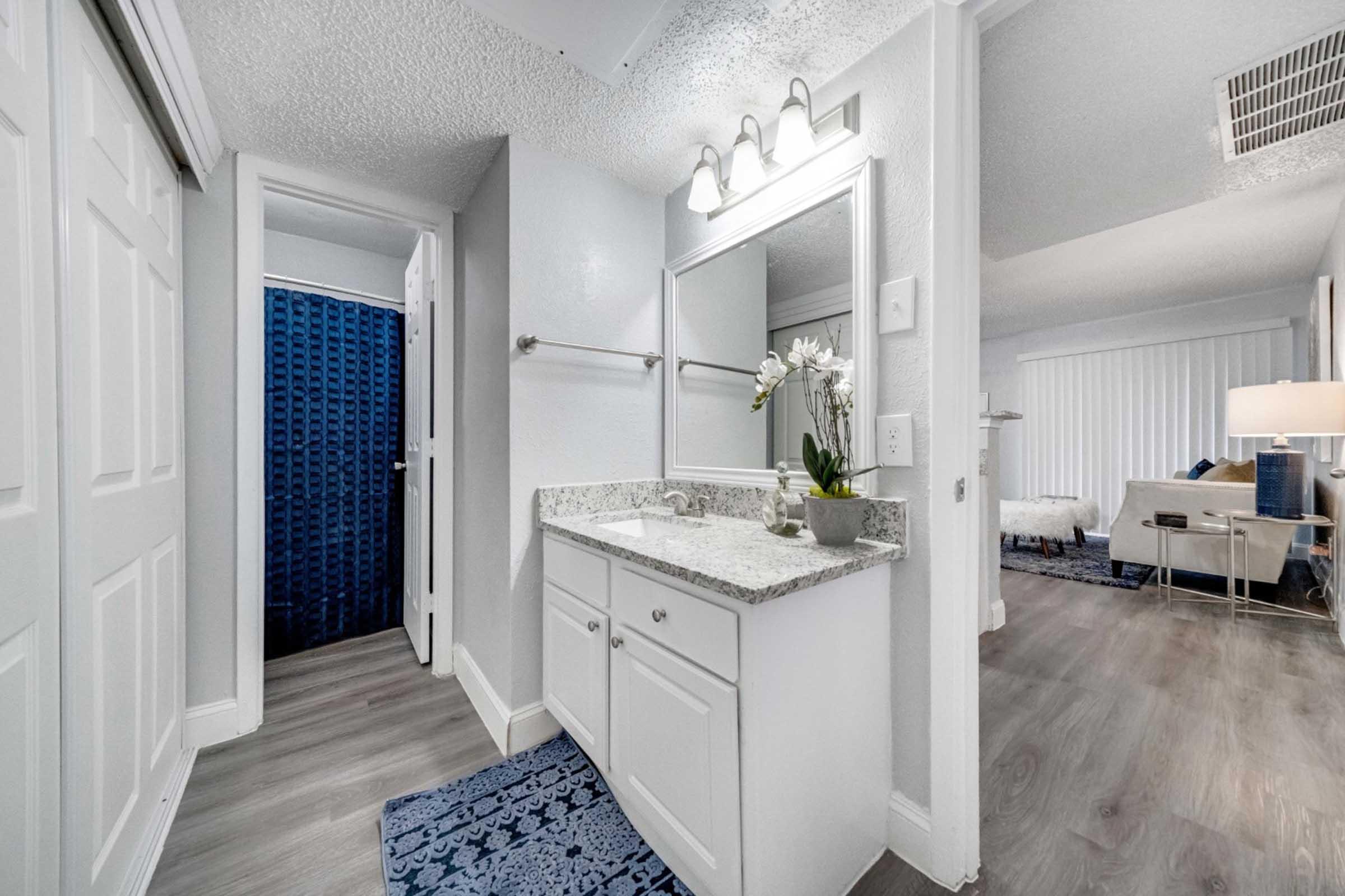 a kitchen with a sink and a mirror in a room