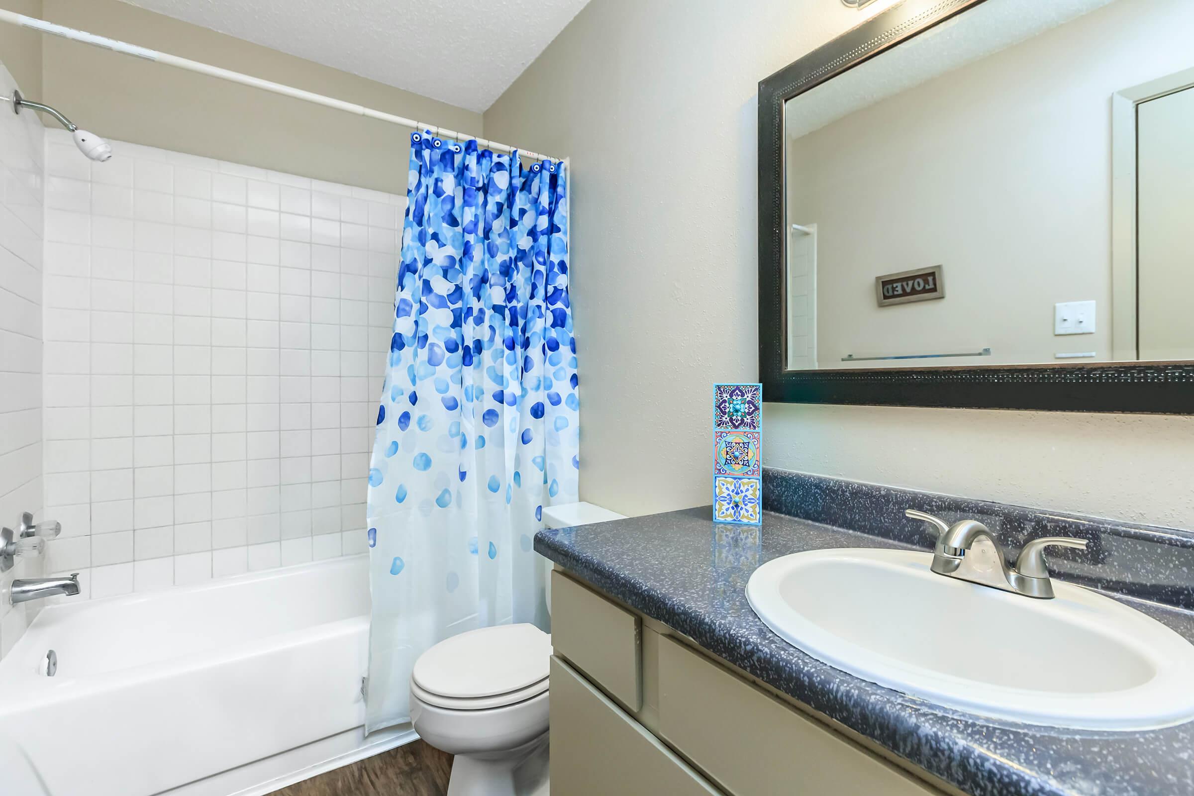 a white sink sitting under a mirror