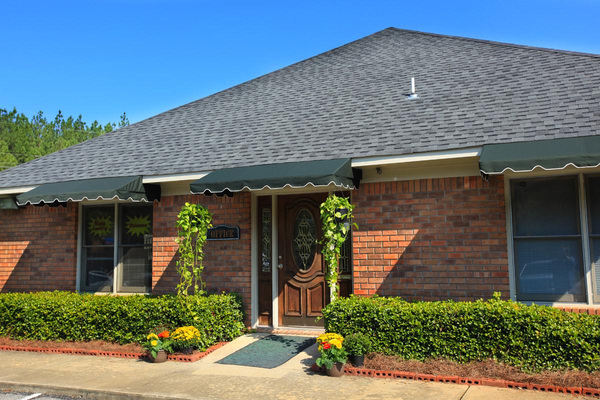 a house with bushes in front of a brick building