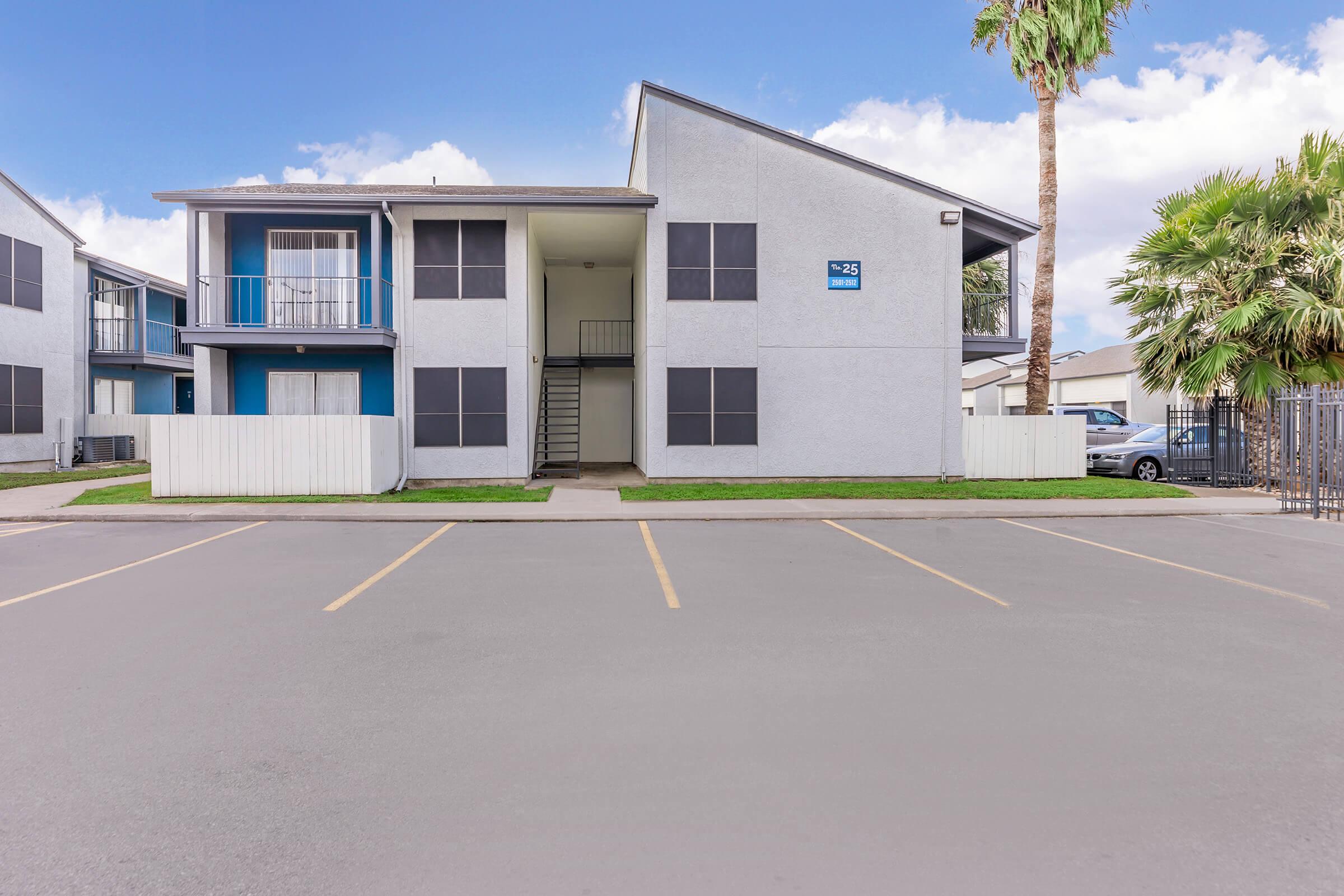 an empty parking lot in front of a house