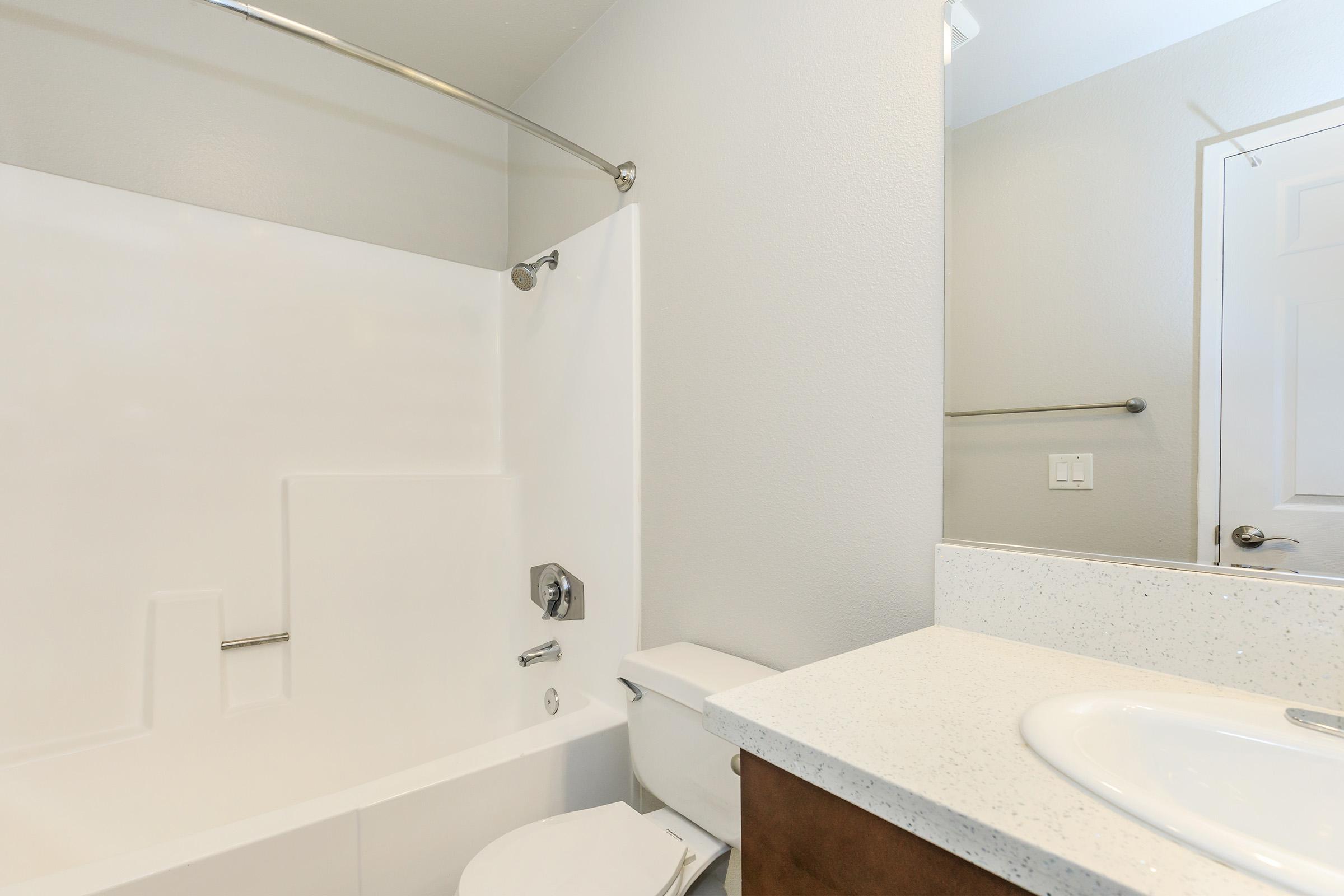 a white sink sitting under a mirror