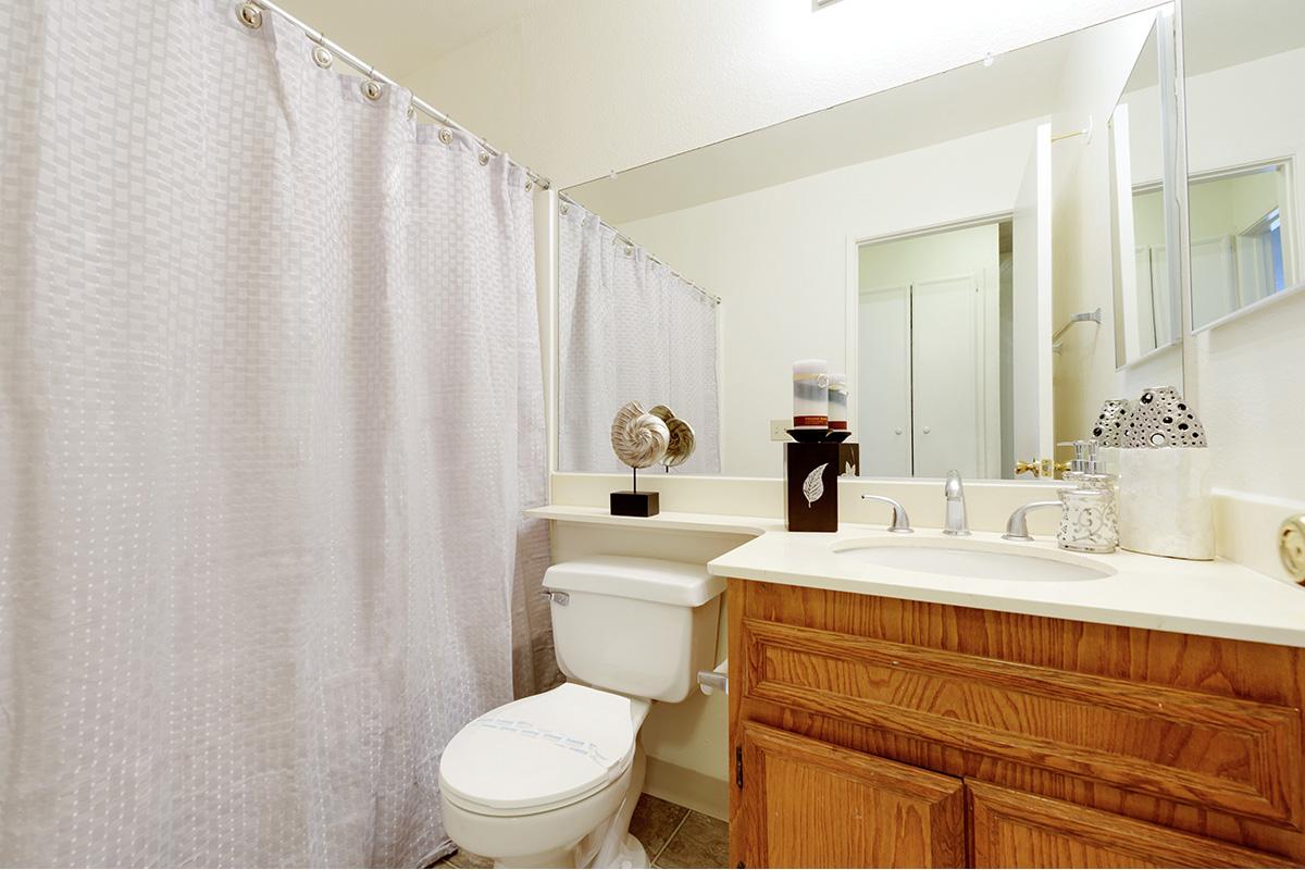 a white sink sitting next to a shower curtain