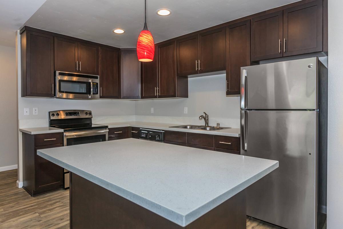 a modern kitchen with stainless steel appliances and wooden cabinets