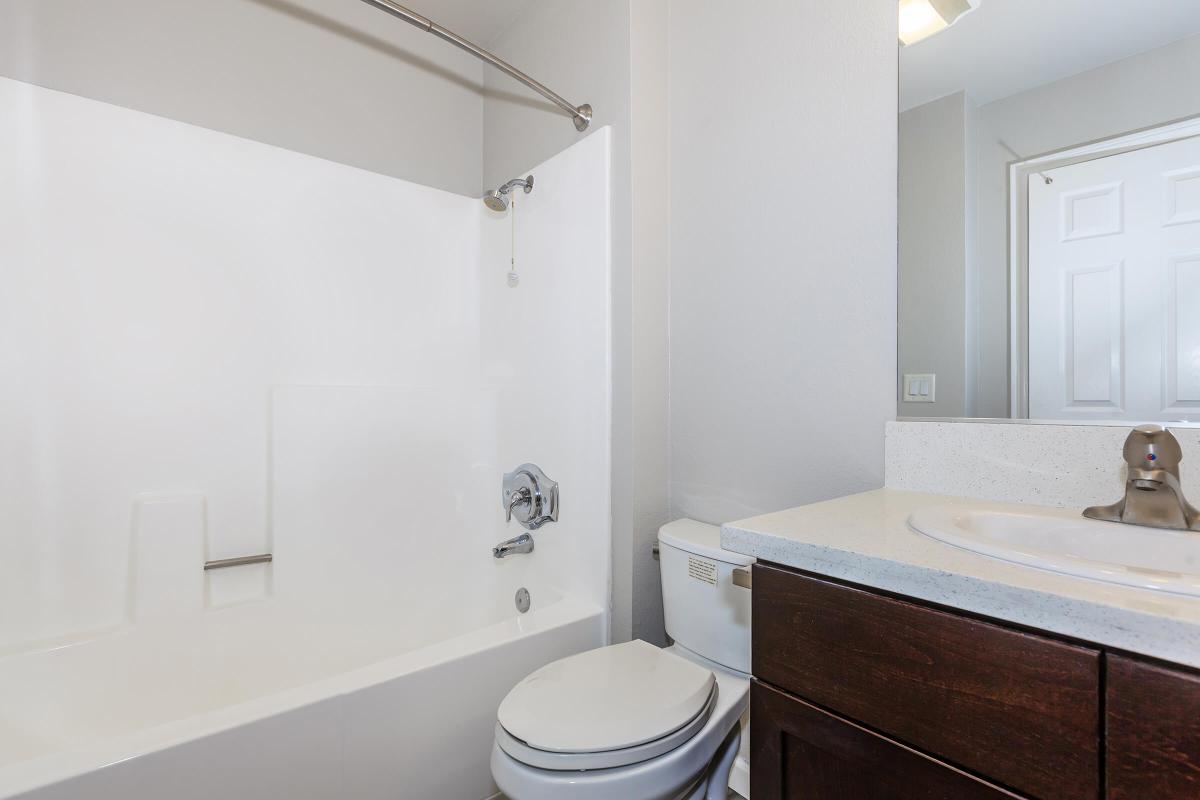 a white sink sitting under a mirror