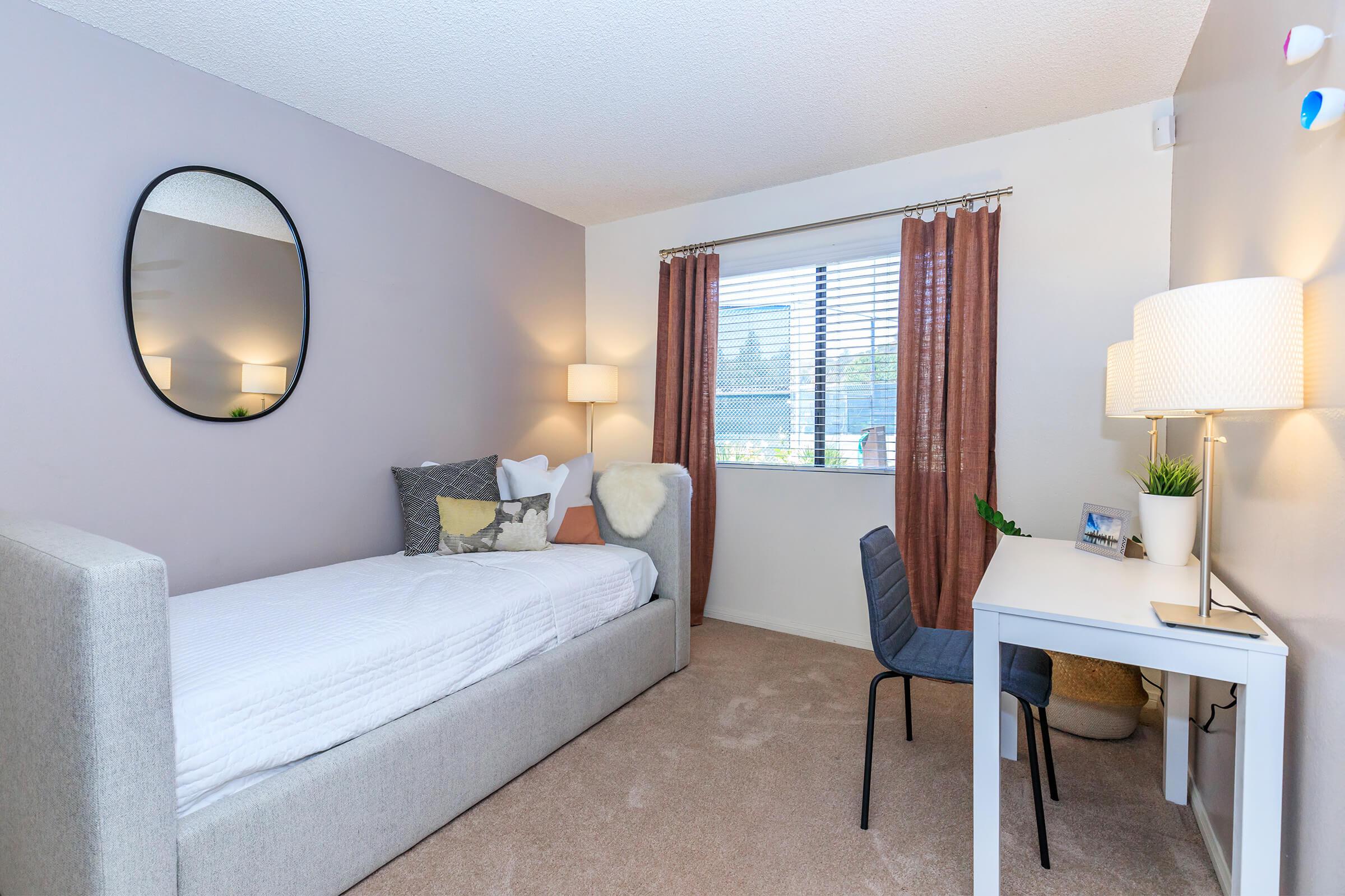 a bedroom with a bed and desk in a hotel room