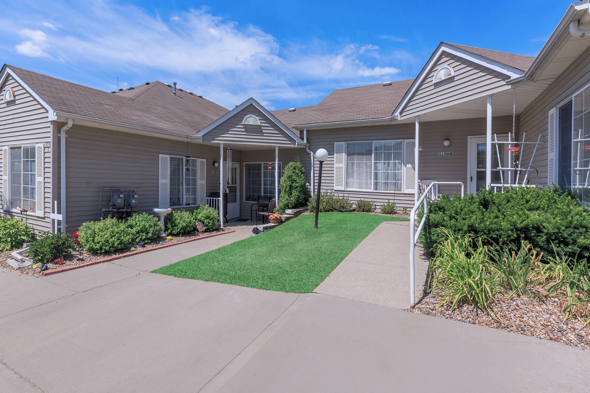 a large brick building with grass in front of a house