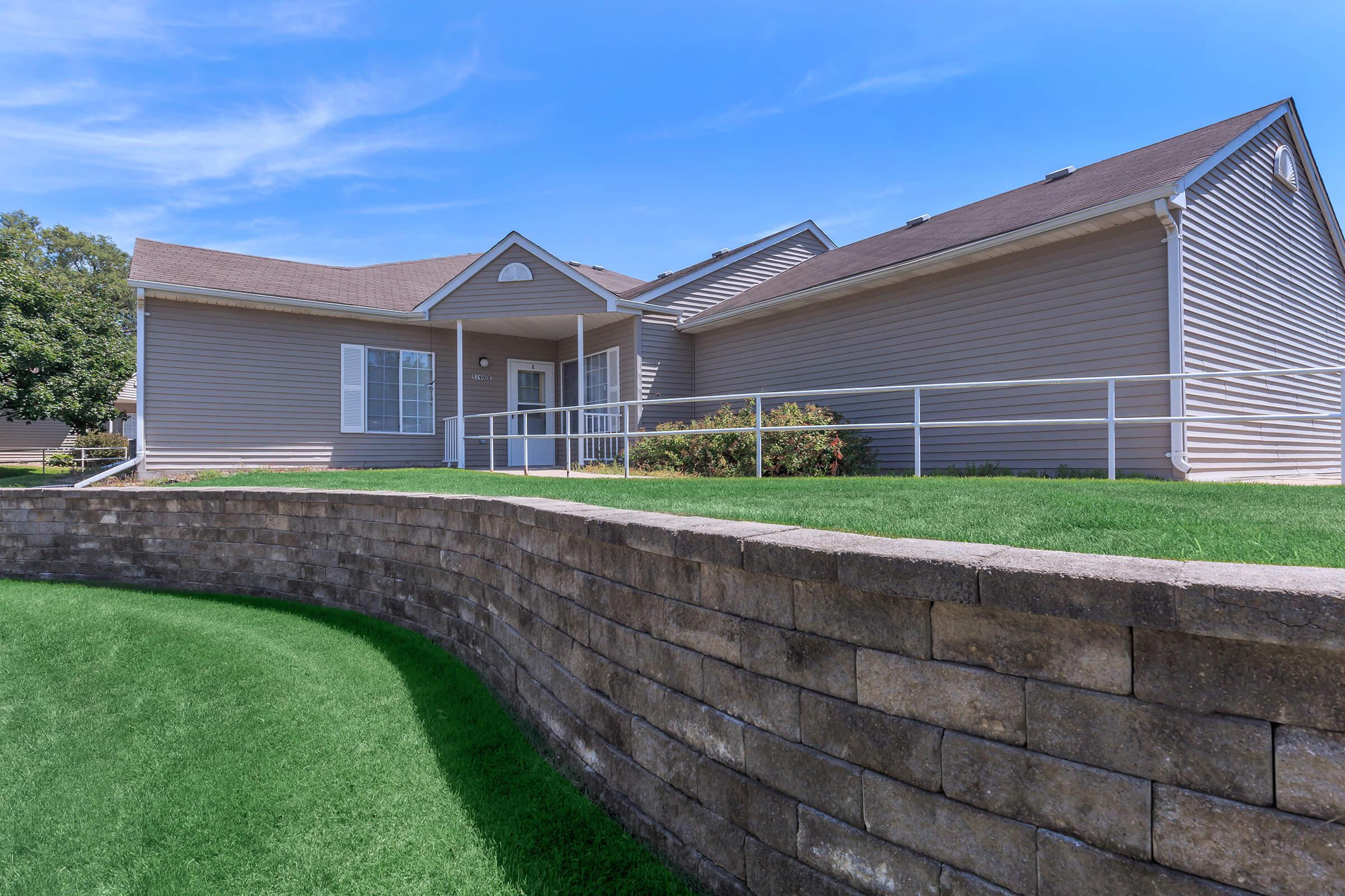 a large brick building with grass and trees