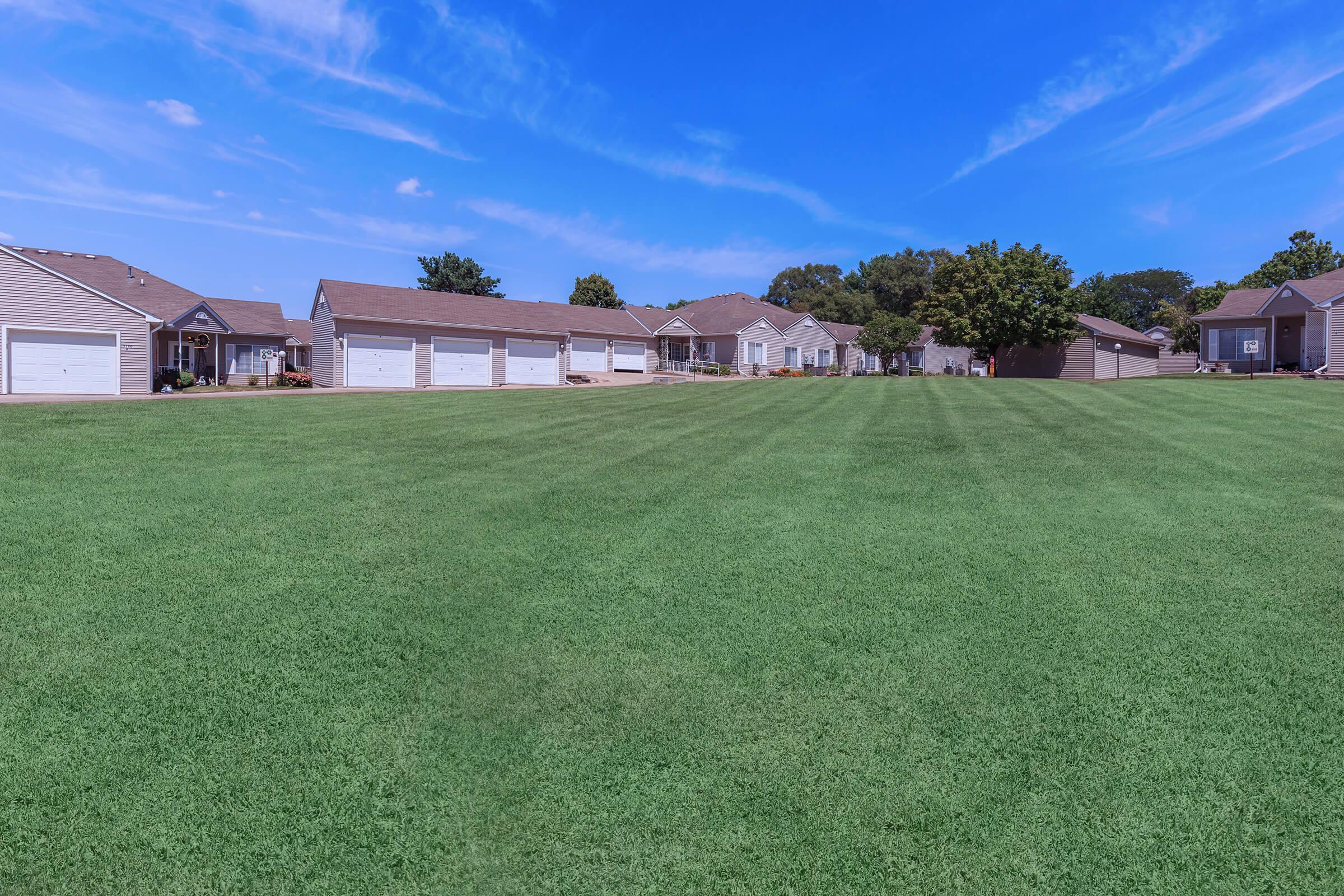 a large green field in front of a house