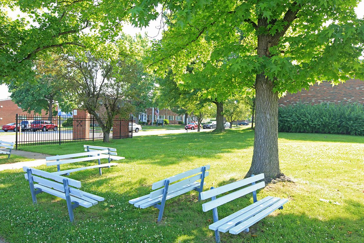 a couple of lawn chairs sitting on top of a bench in a park