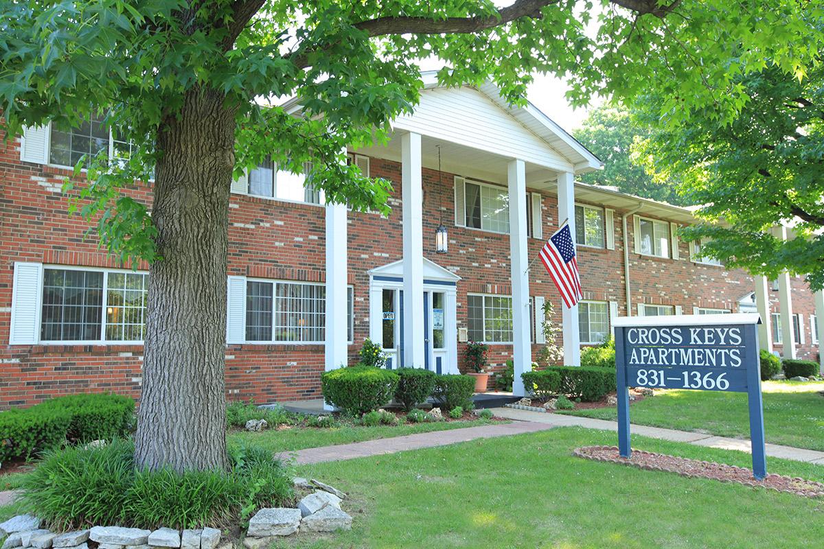 a house with a lawn in front of a brick building