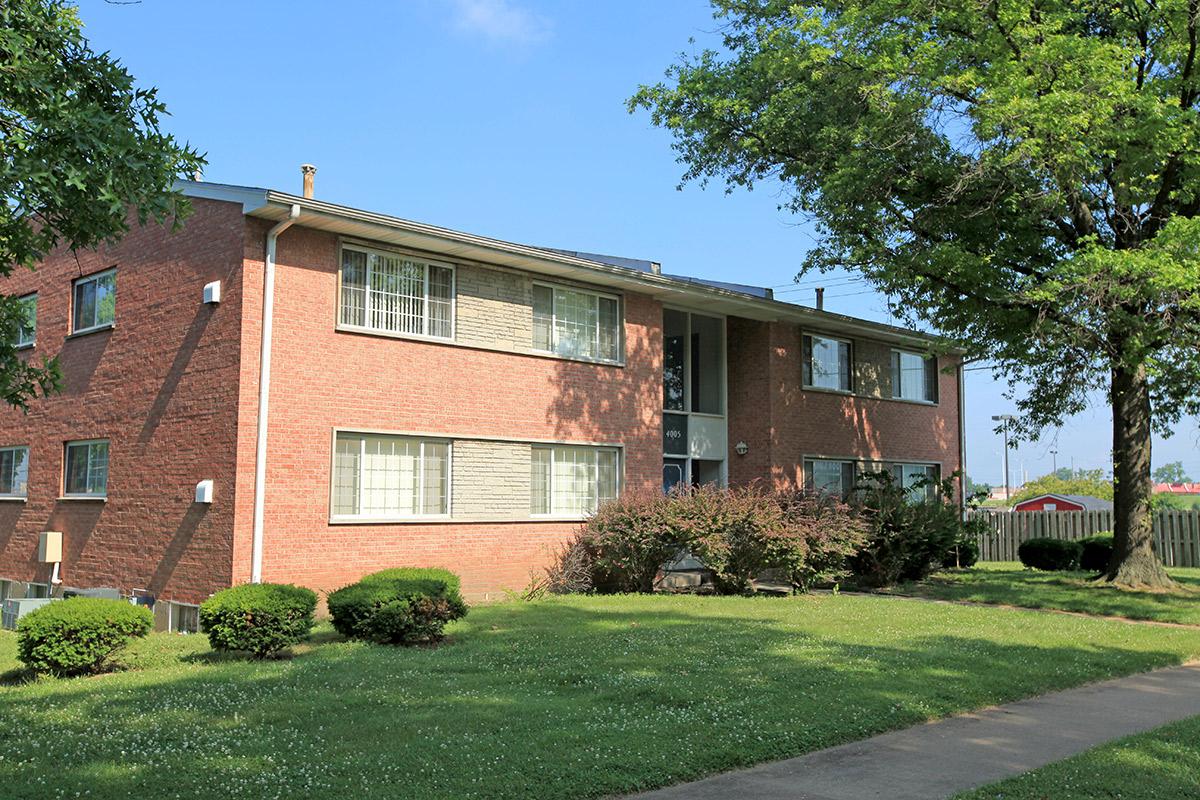 a house with a lawn in front of a brick building