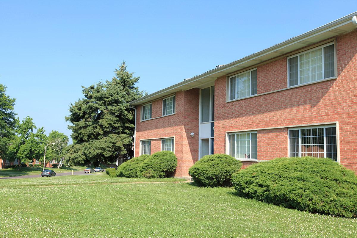 a large lawn in front of a brick building