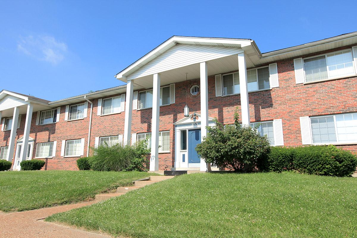 a large lawn in front of a brick building