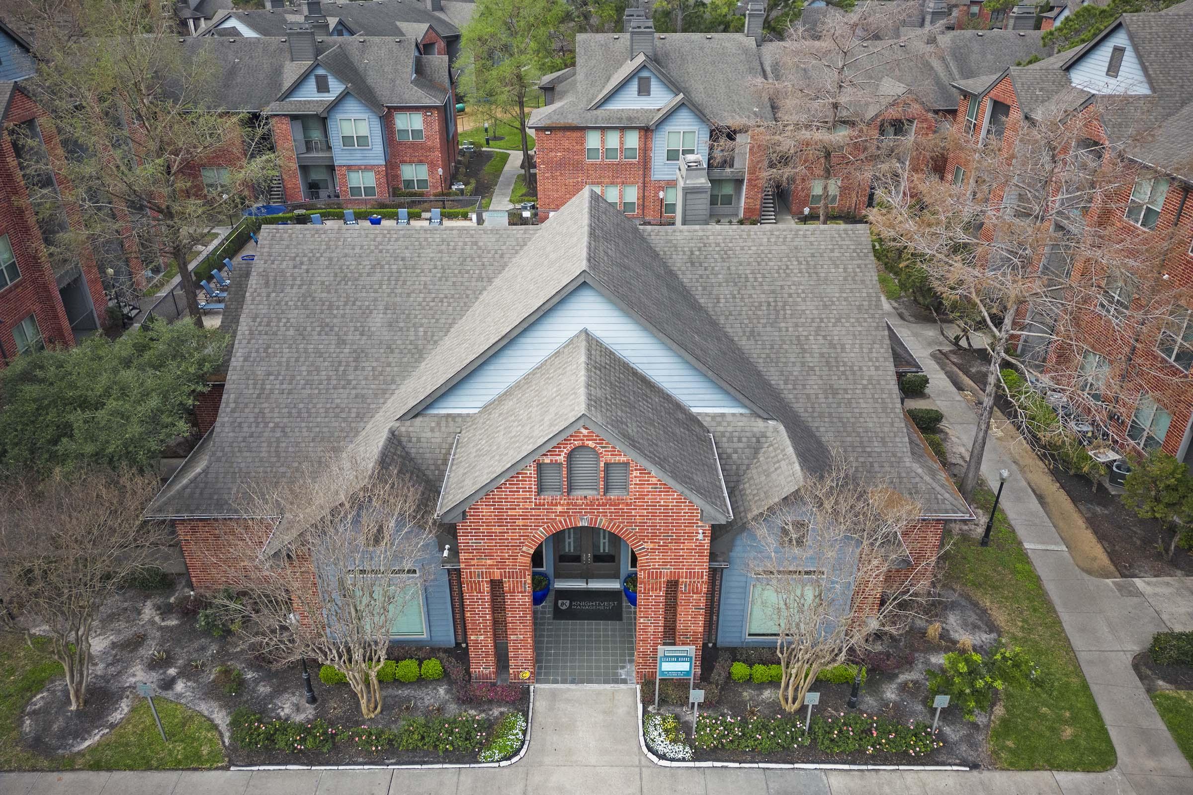 a large brick building with grass in front of a house