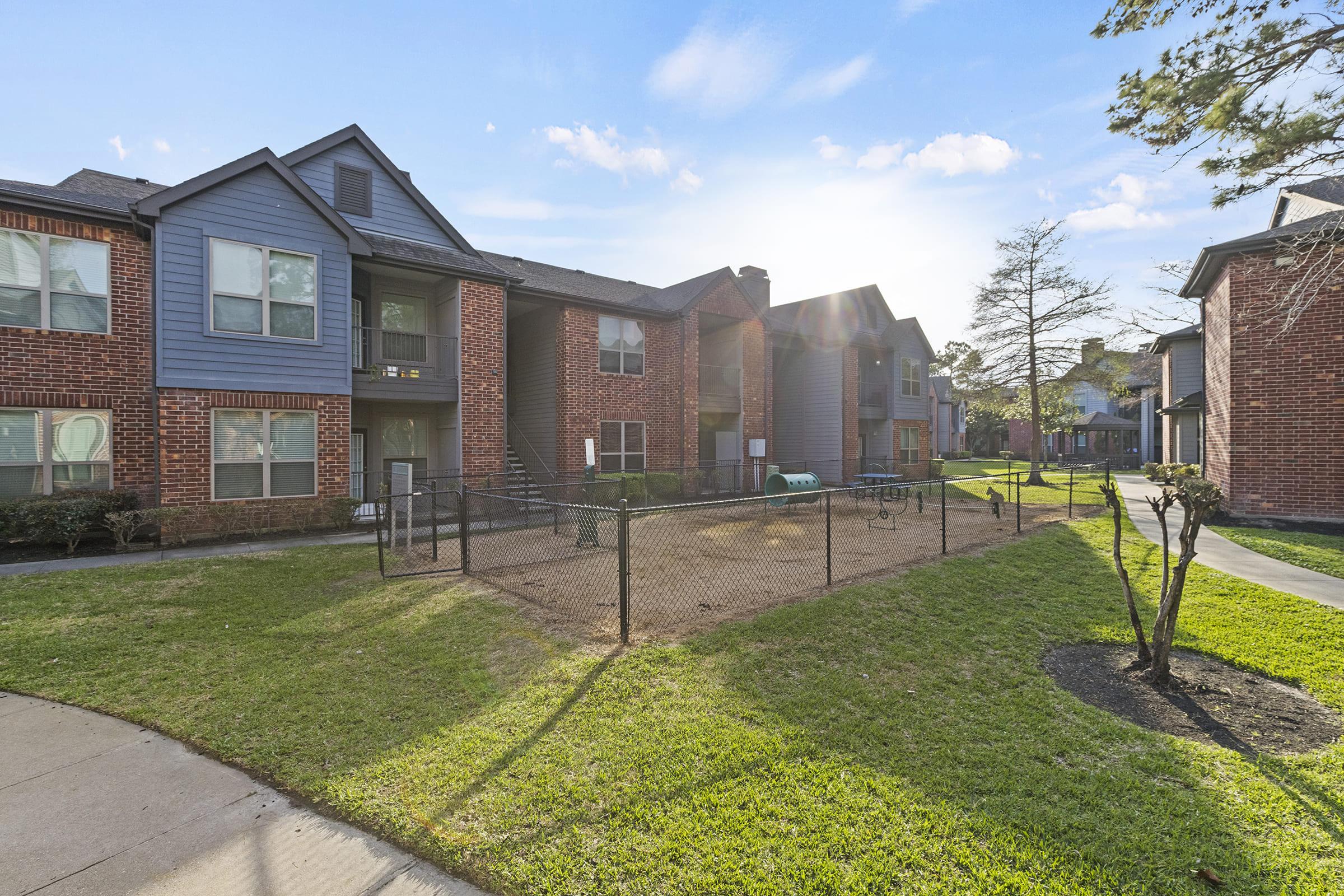 a house with a lawn in front of a brick building