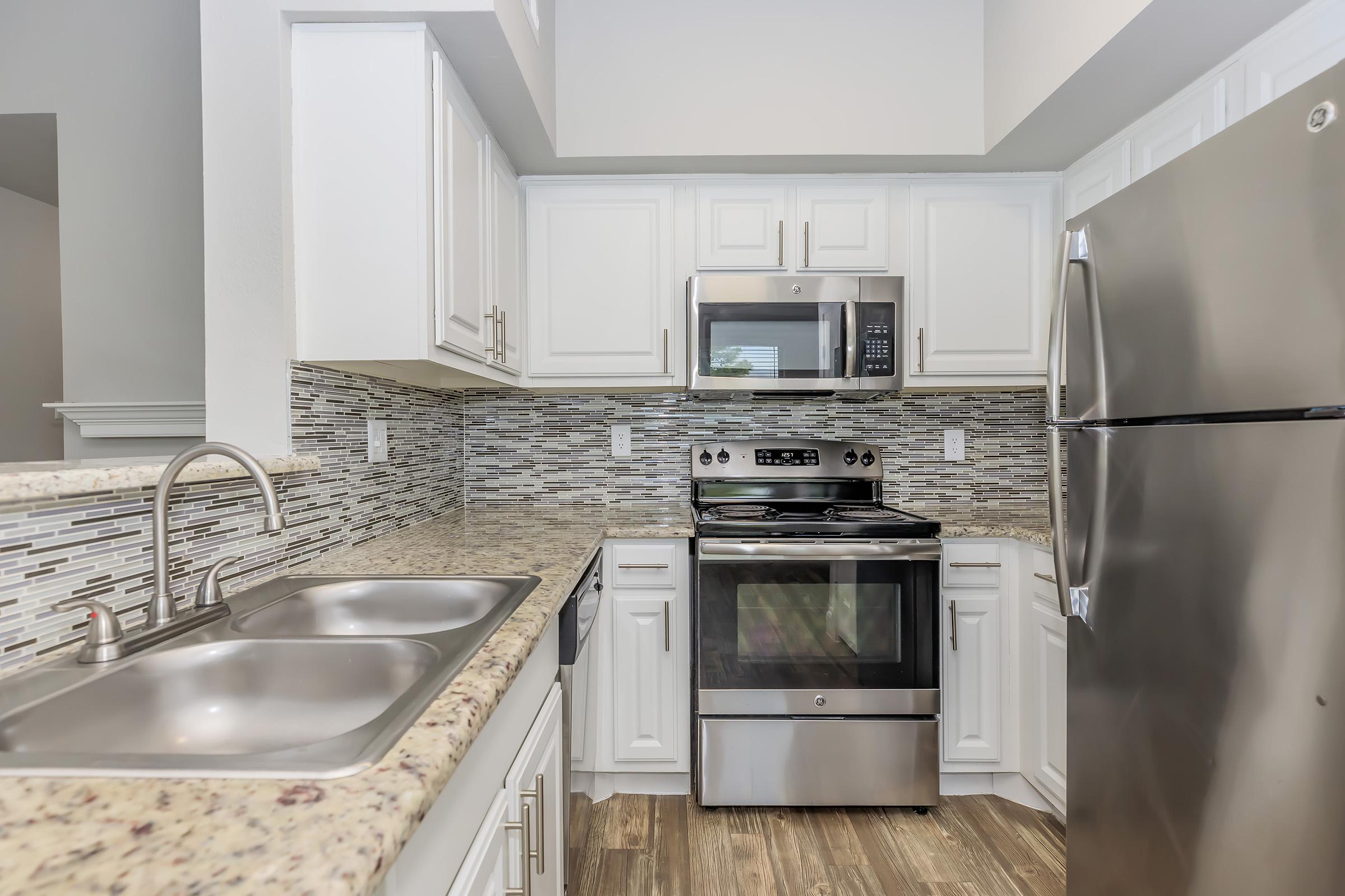 a stove top oven sitting inside of a kitchen