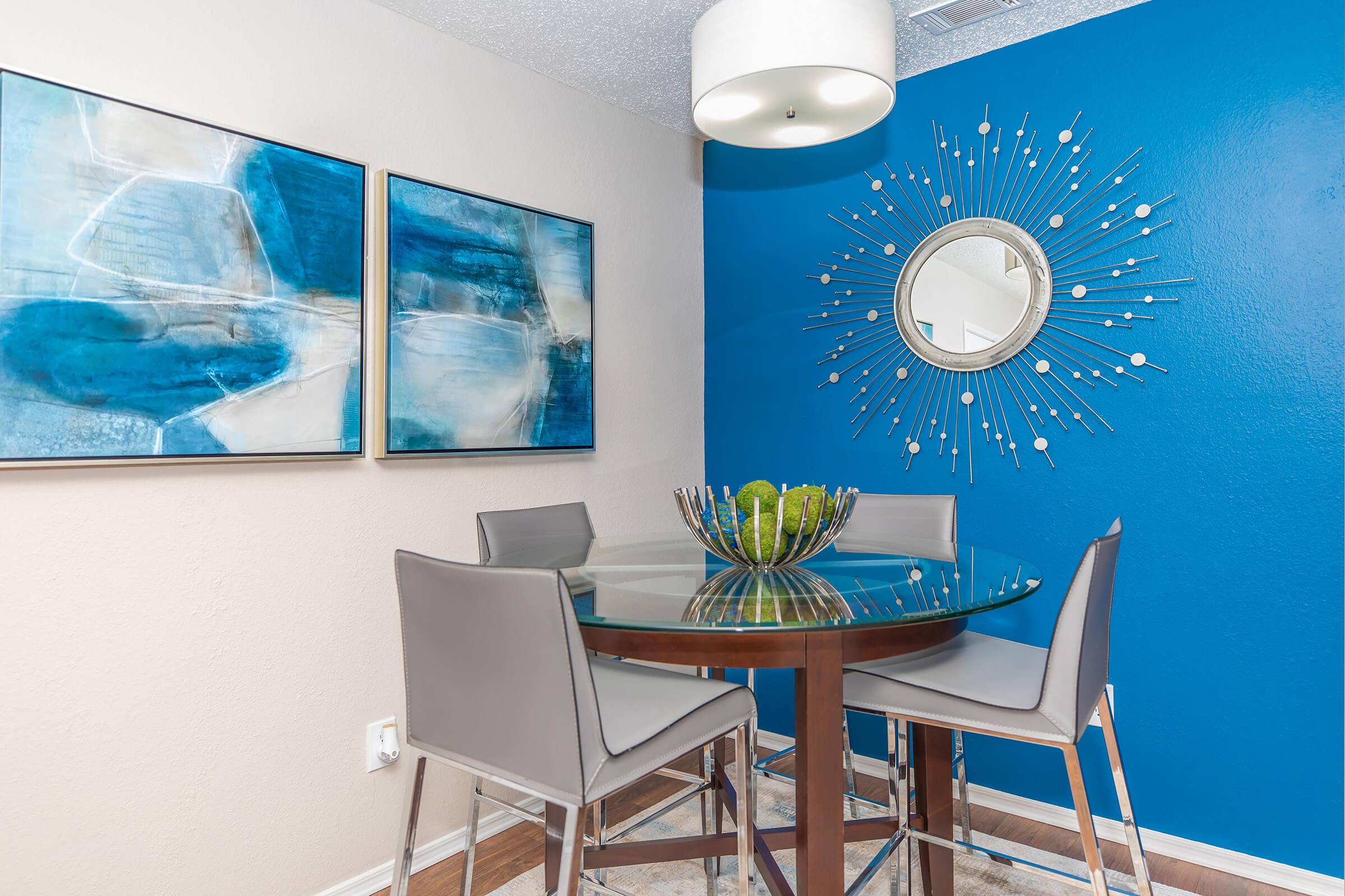 A dining area with a table and chairs in the clubhouse at Rise Oak Creek.