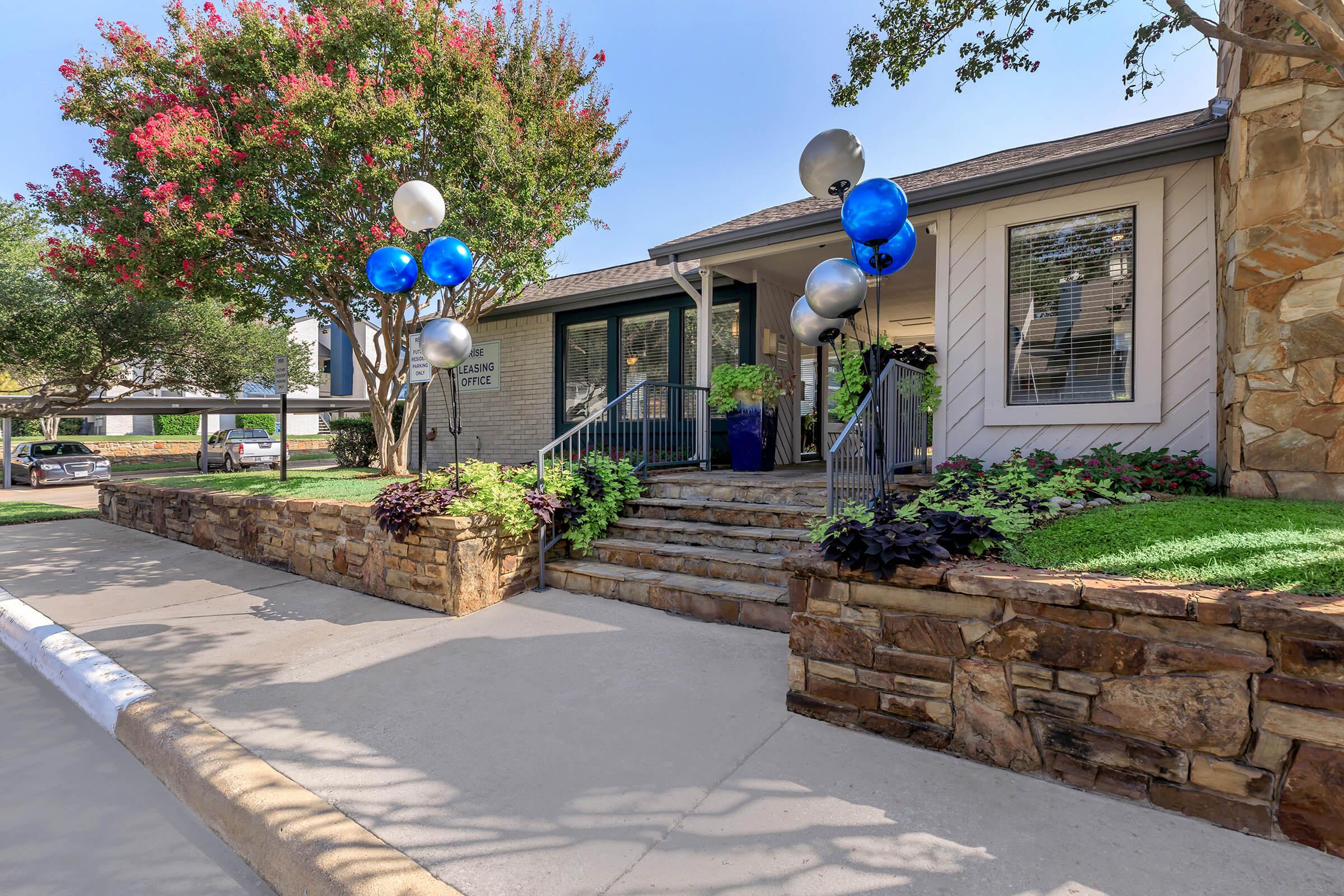 The exterior of the leasing office with welcoming balloons at Rise Oak Creek.