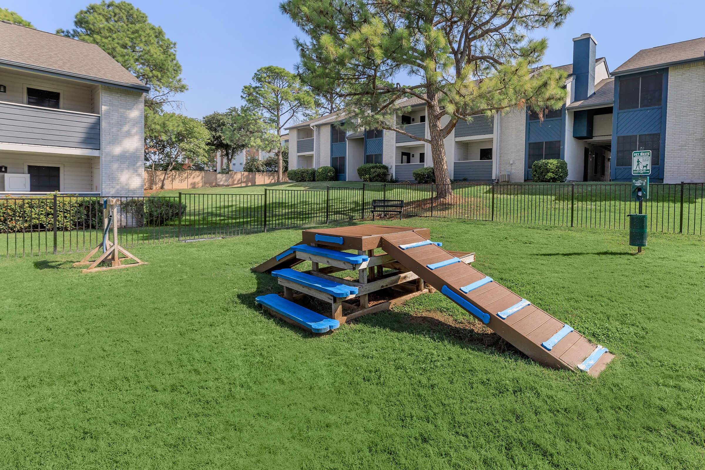 A dog park with a dog hurdle at Rise Oak Creek in Bedford, TX.