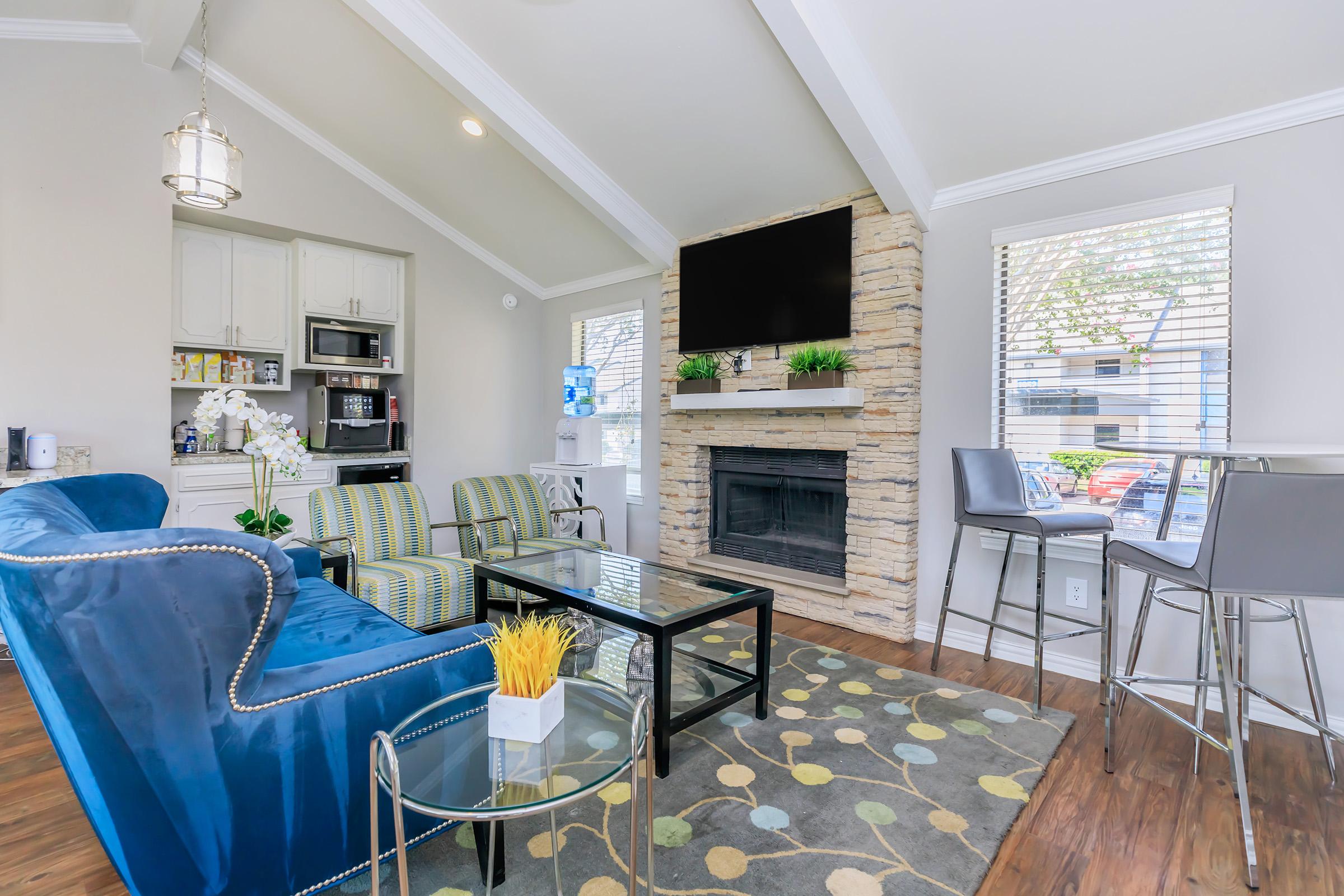 A living space at the clubhouse at Rise Oak Creek with furniture and a kitchen.