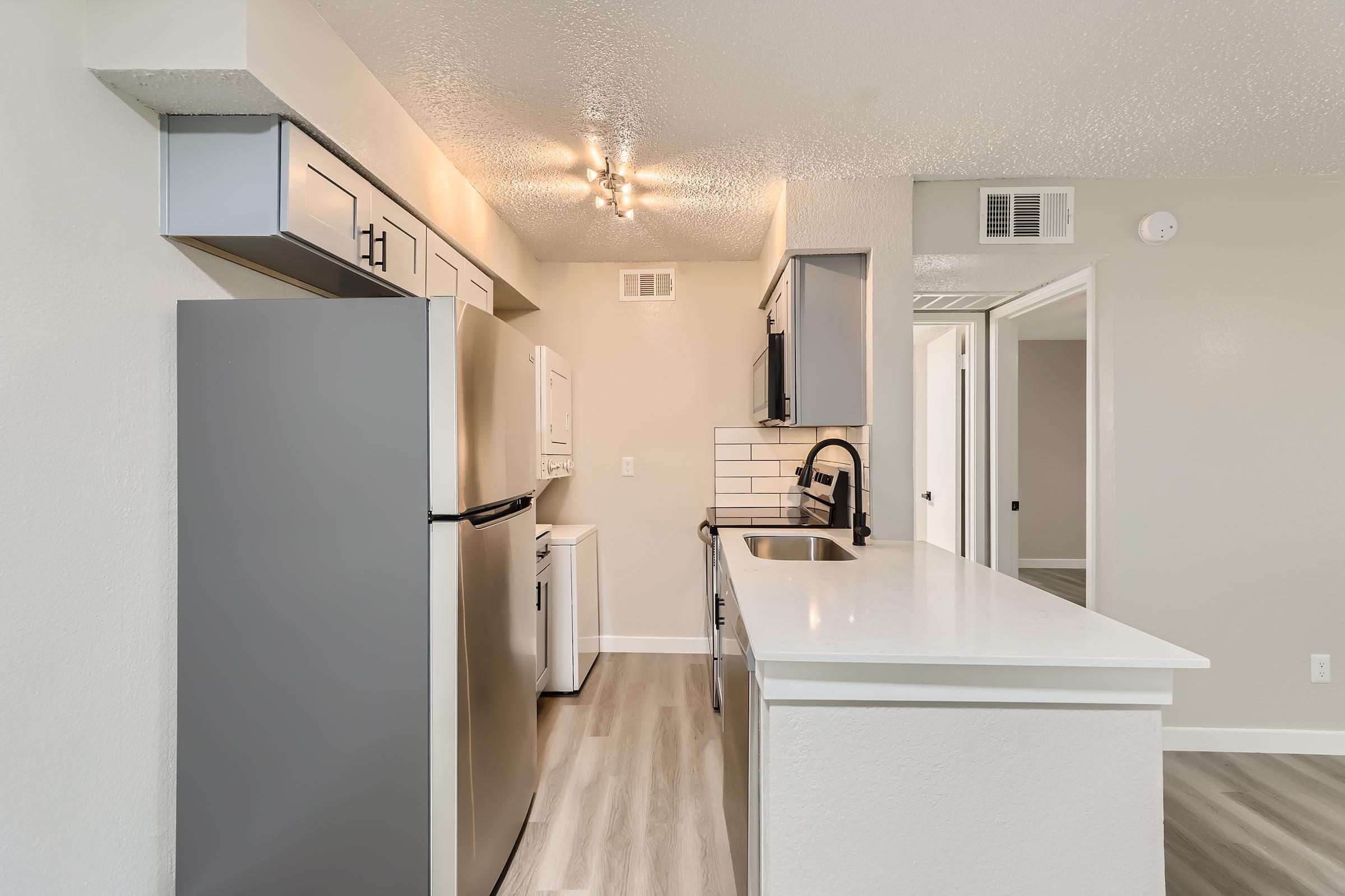 A remodeled kitchen with quartz countertops and stainless steel appliances at Rise Oak Creek.