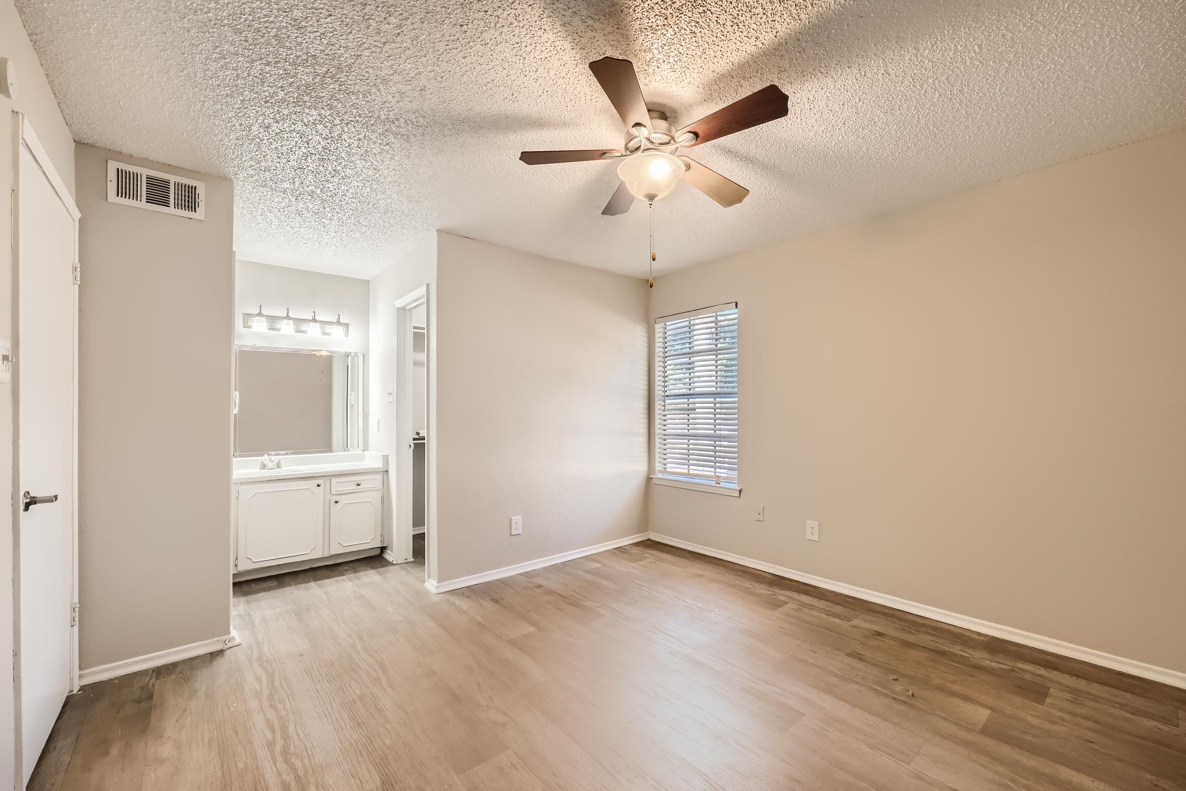 A large bedroom with an en-suite bathroom and separate vanity area at Rise Oak Creek.