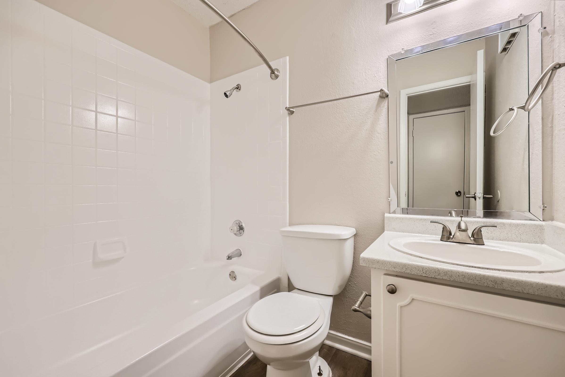 A Rise Oak Creek bathroom with a white vanity and mirror.