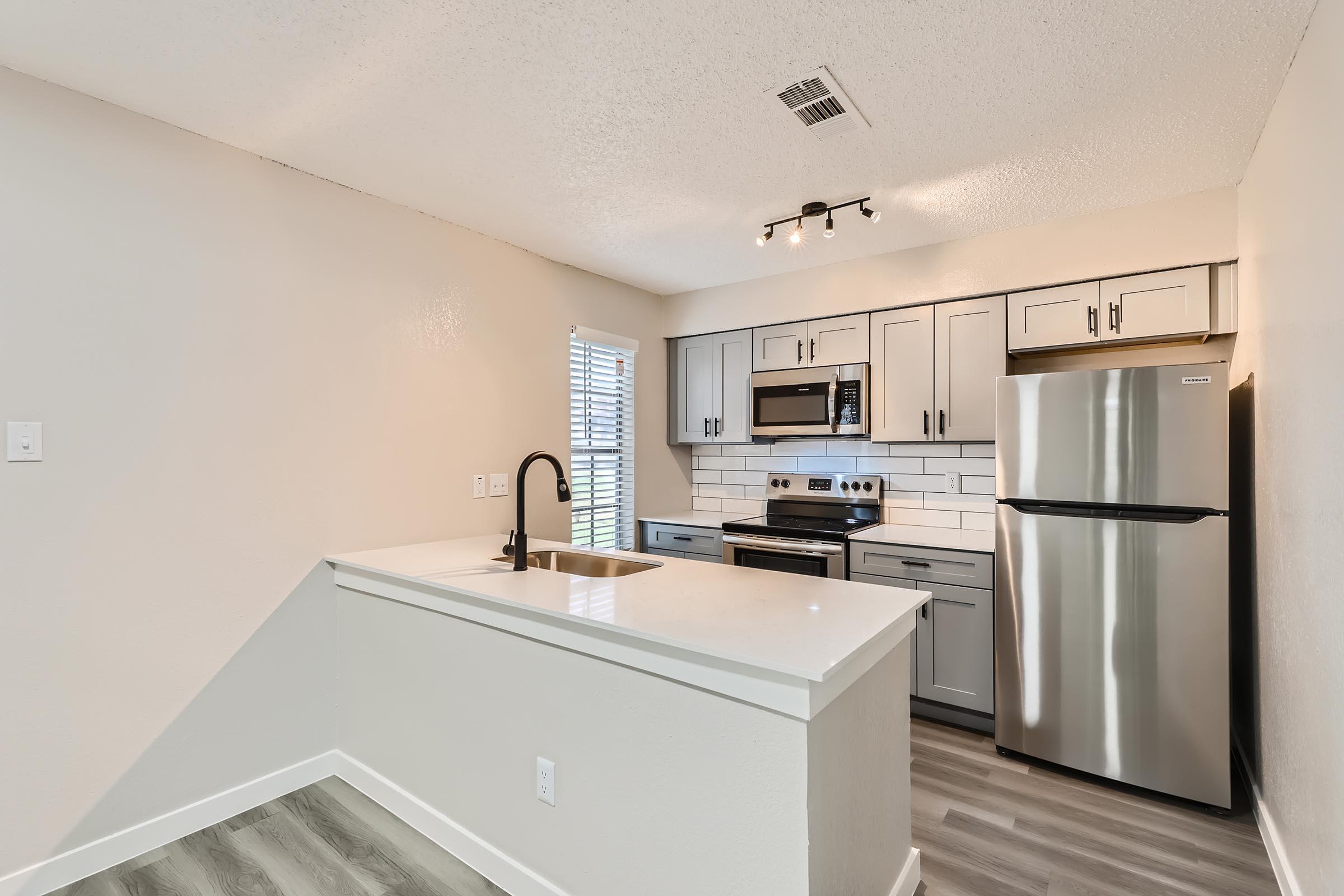 a kitchen with a sink and a refrigerator