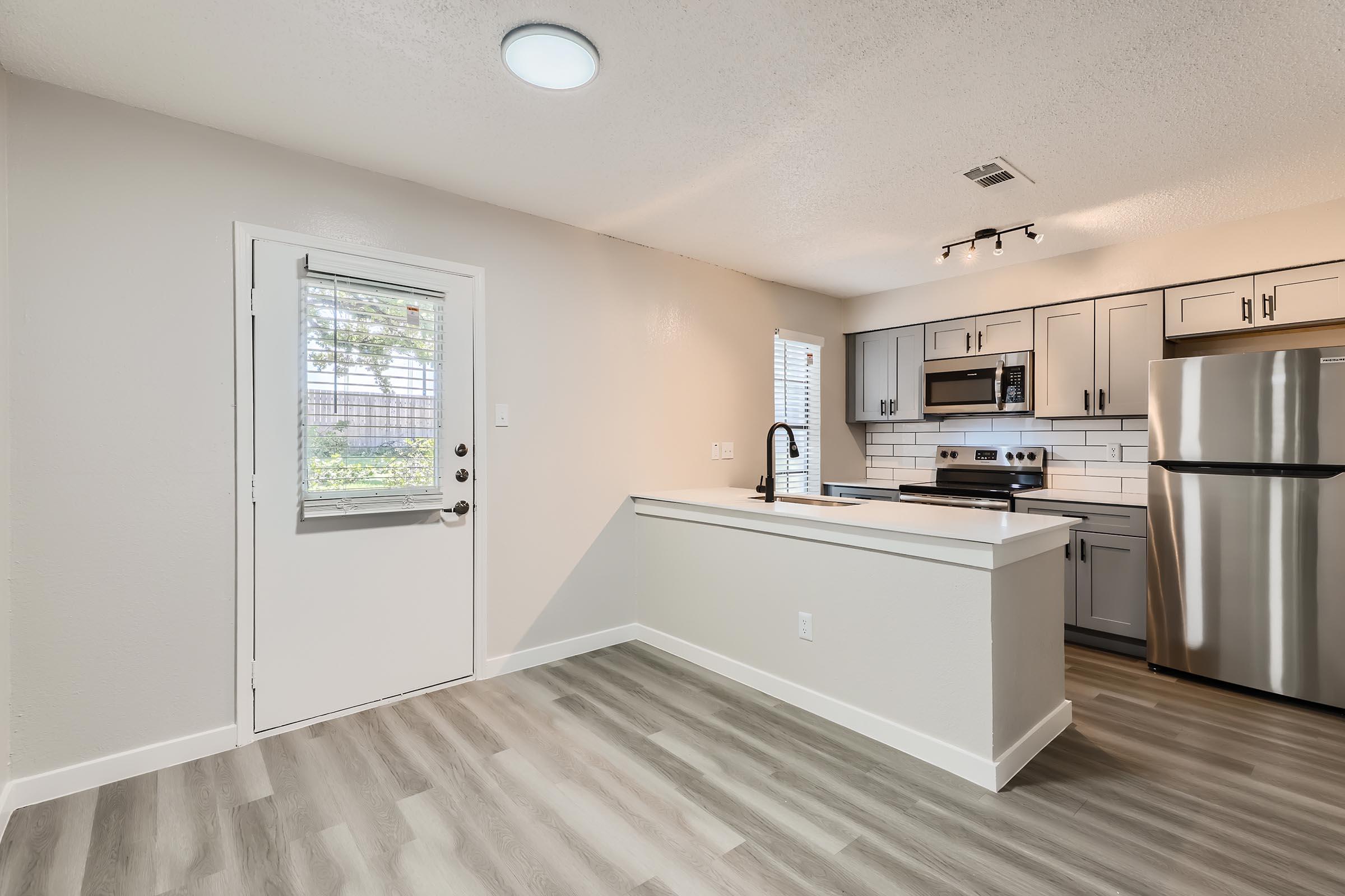 A kitchen and dining space with wood-style flooring at Rise Oak Creek