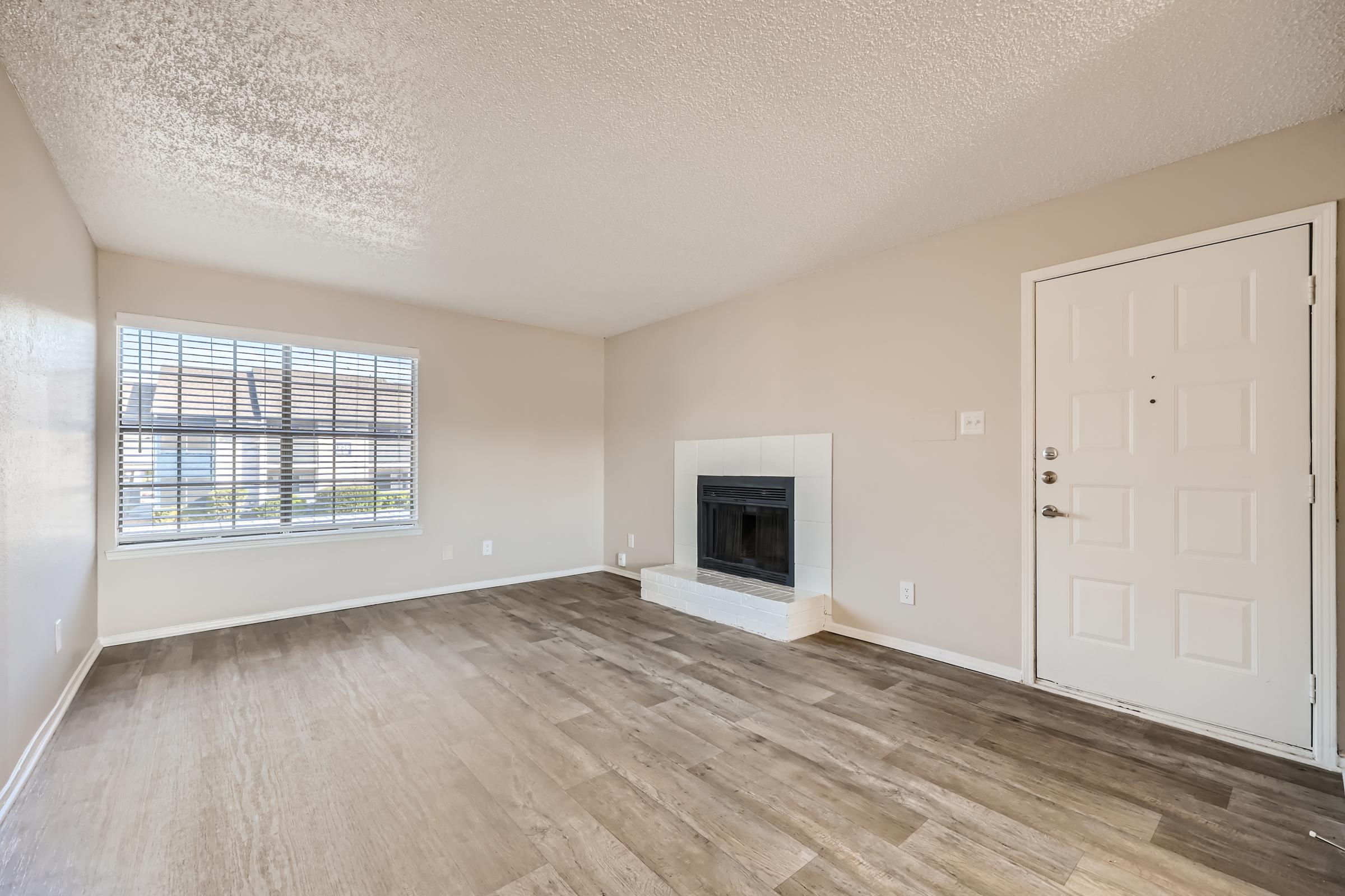 A large living room with a fireplace and a window at Rise Oak Creek.