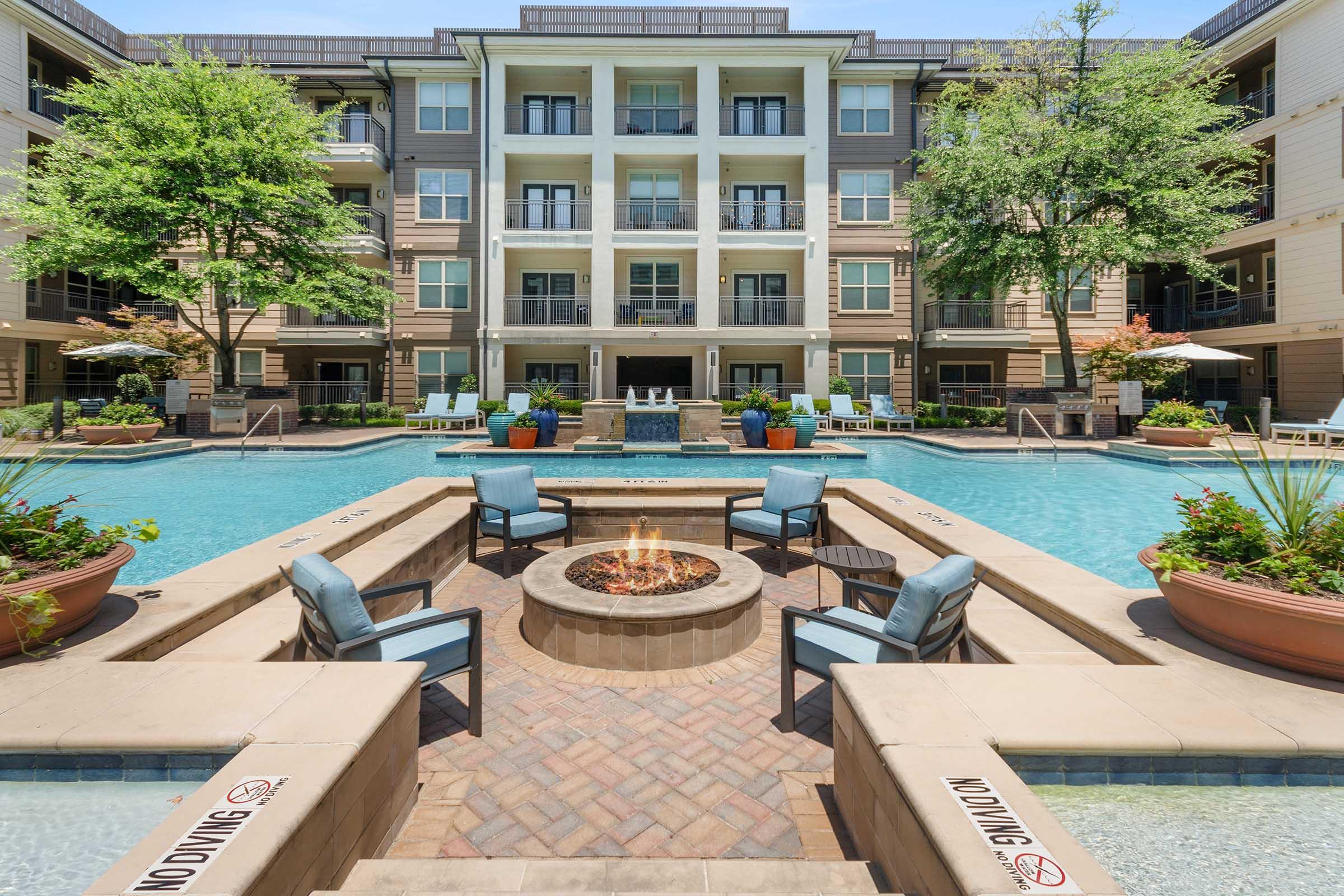 A serene outdoor area featuring a swimming pool surrounded by modern apartment buildings.