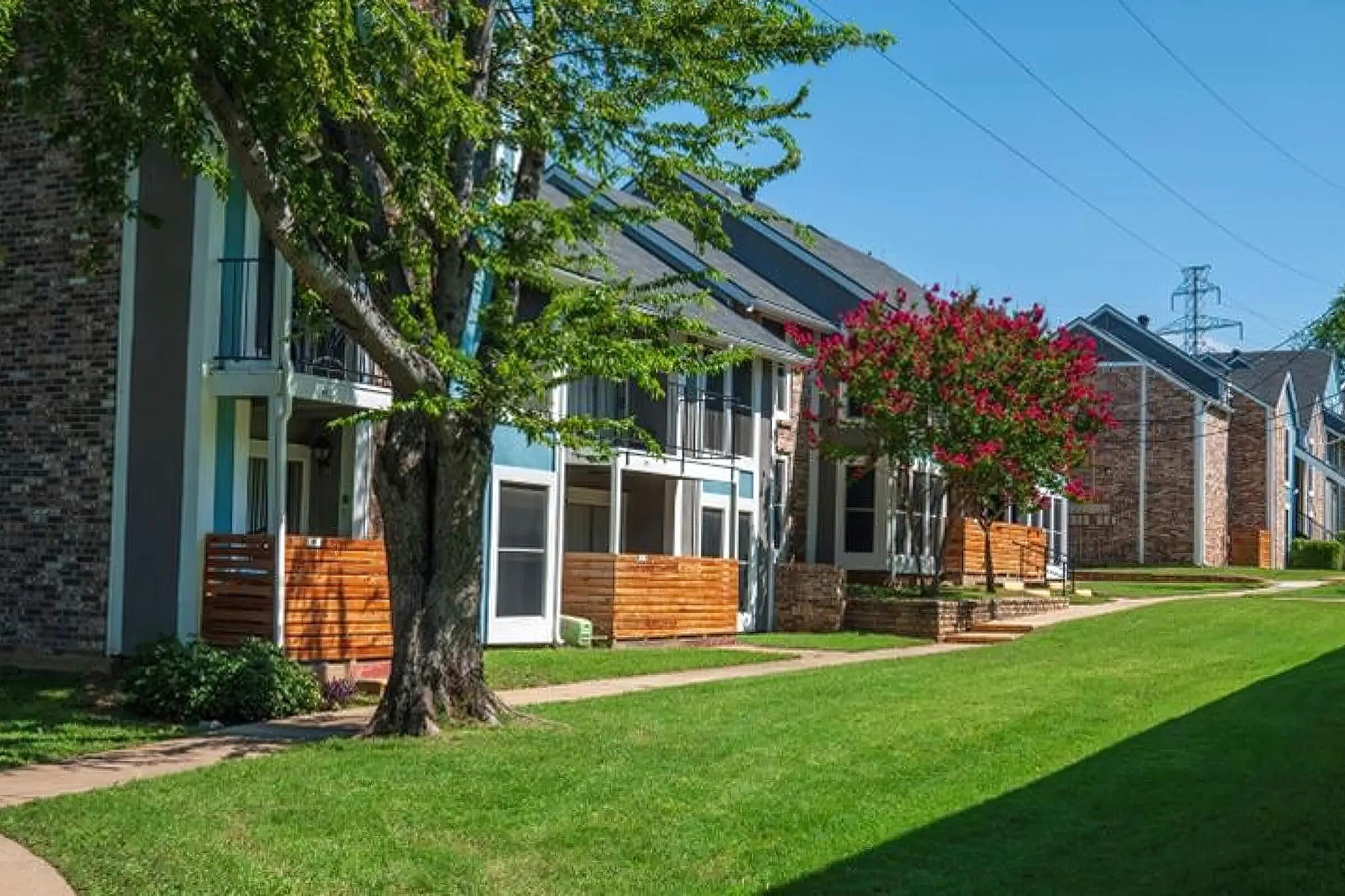 a house with a lawn in front of a brick building