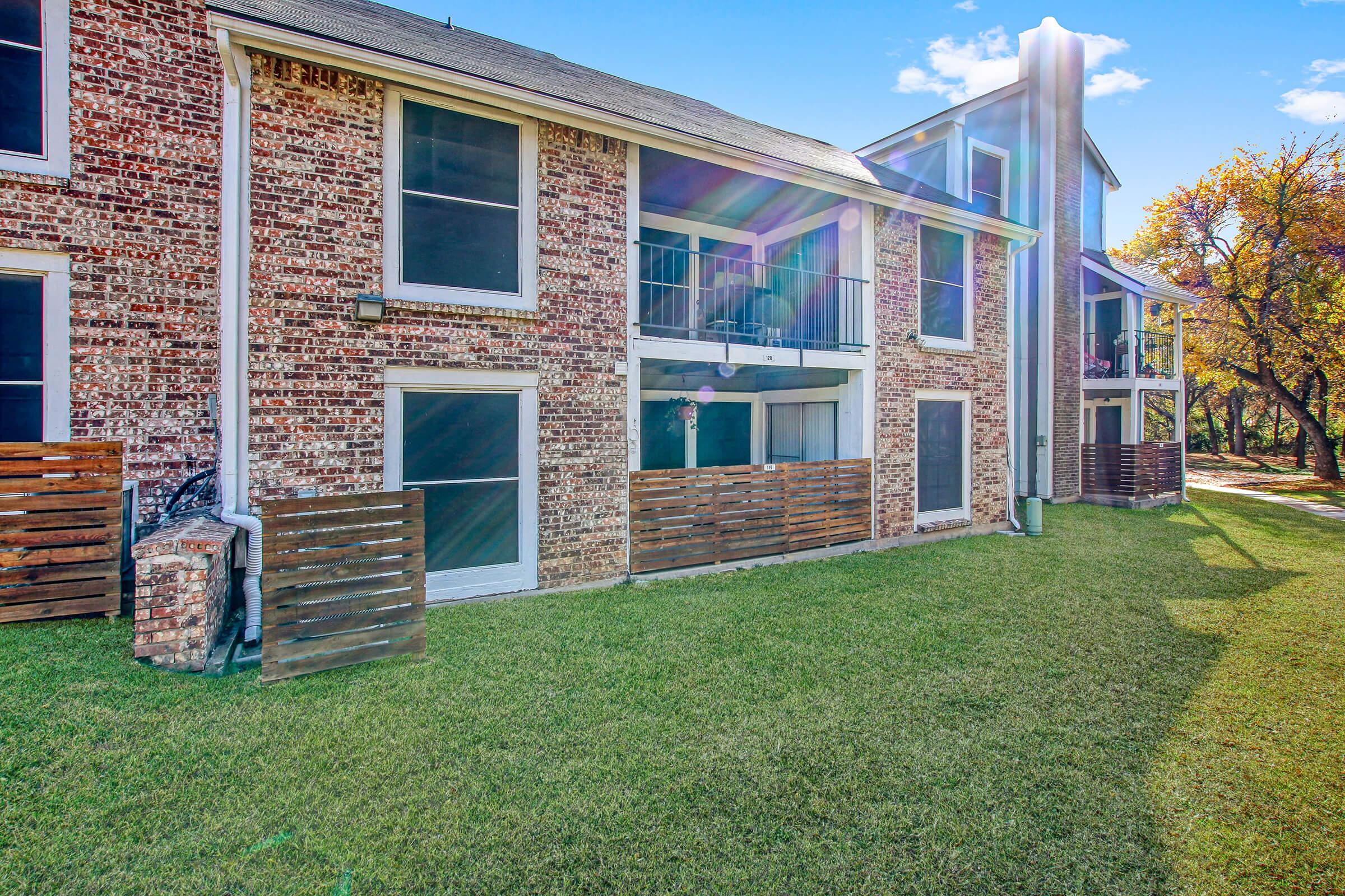 a large lawn in front of a brick building