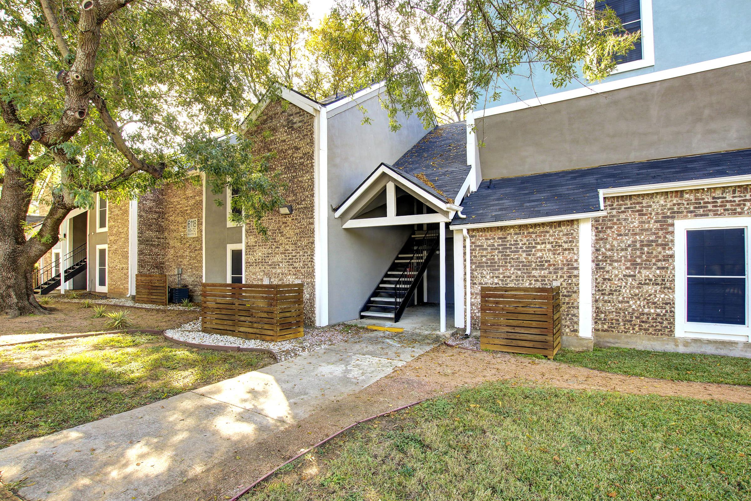 a house with a lawn in front of a brick building