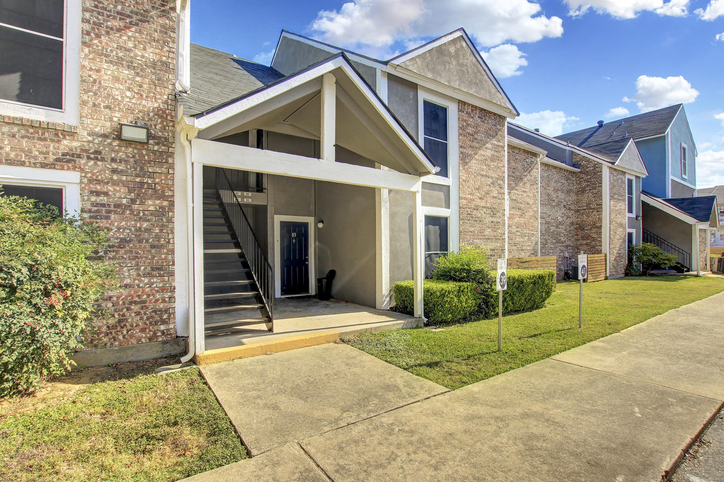 a large brick building with grass in front of a house