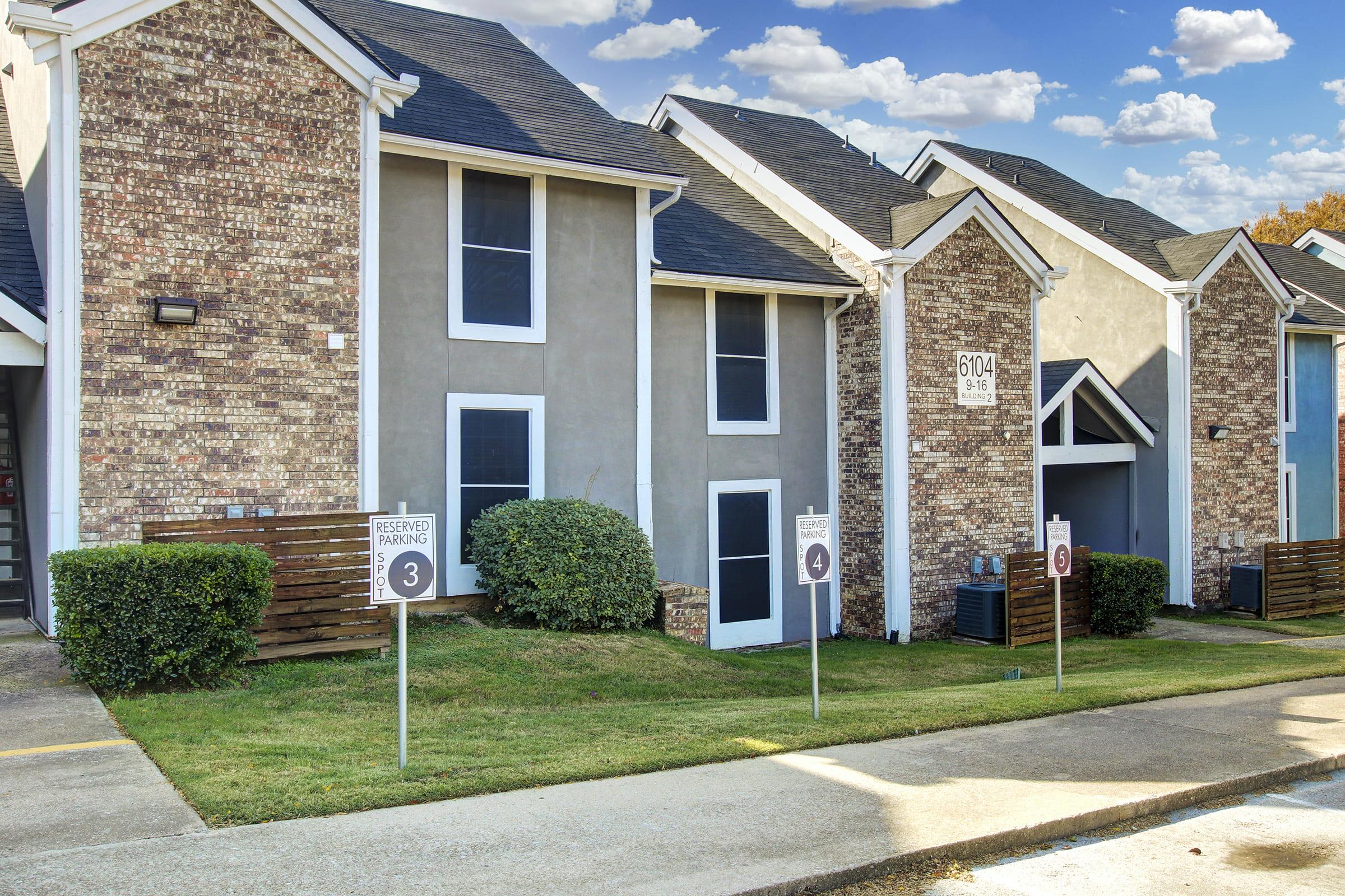 a large brick building with grass in front of a house