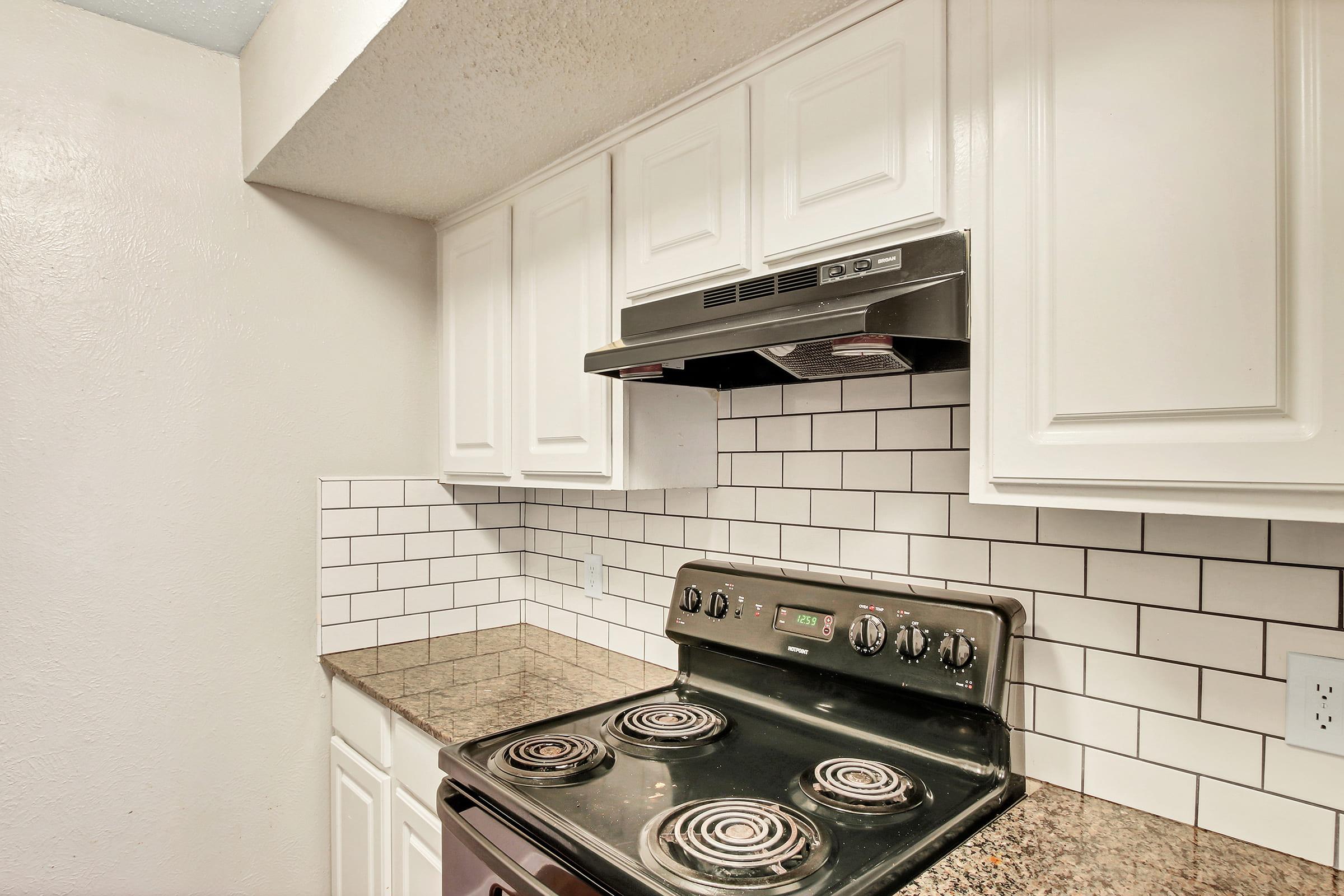 a stove top oven sitting inside of a kitchen