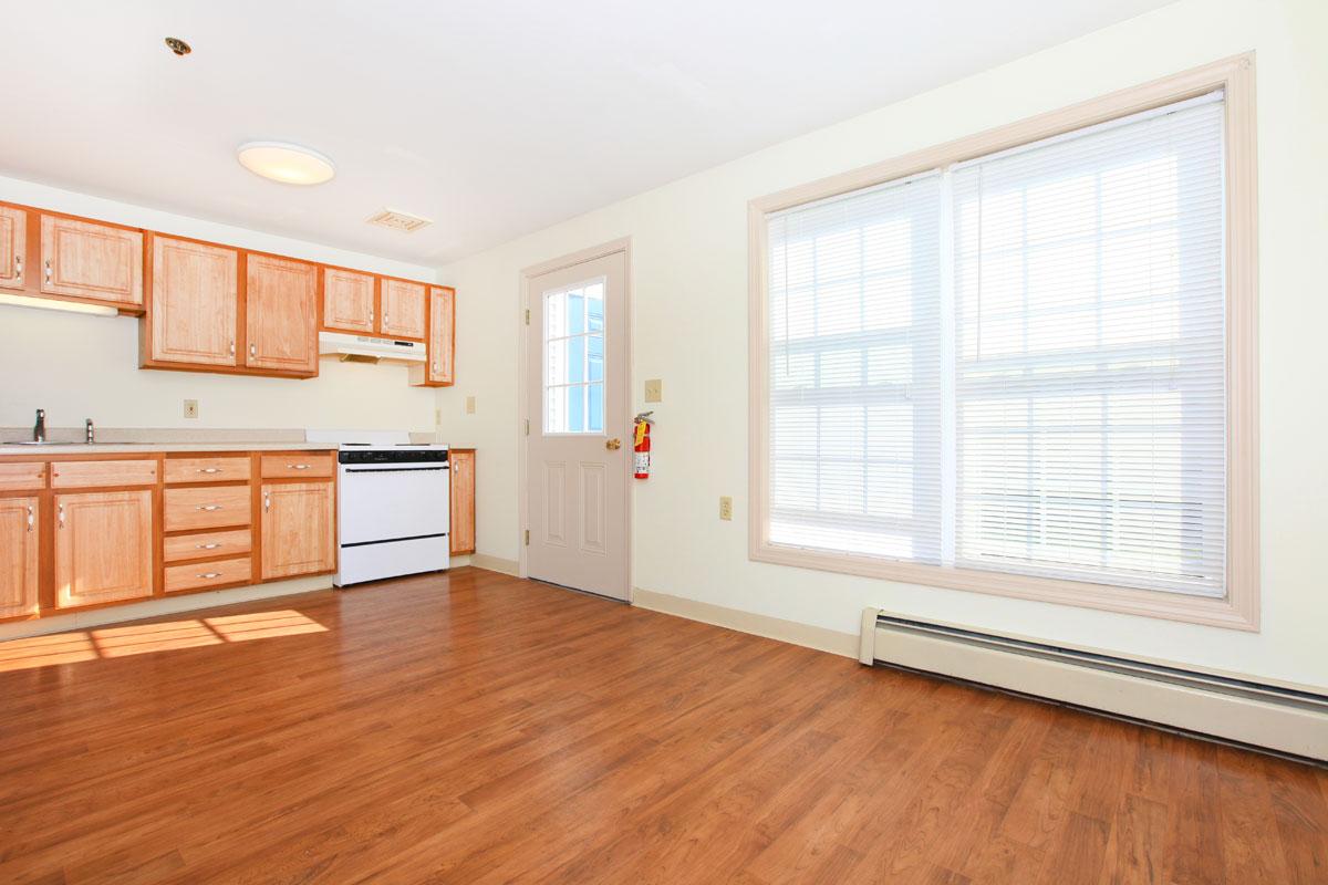 a kitchen with hard wood floors and a large window