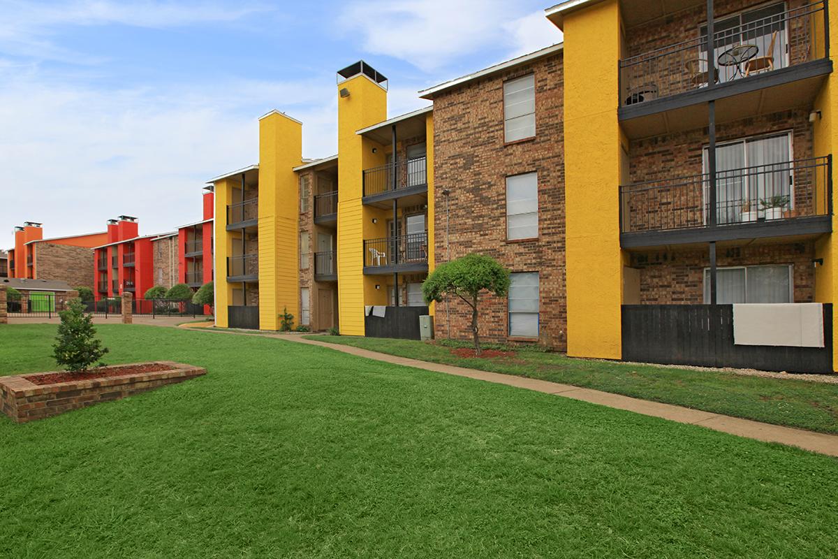 a large lawn in front of a brick building