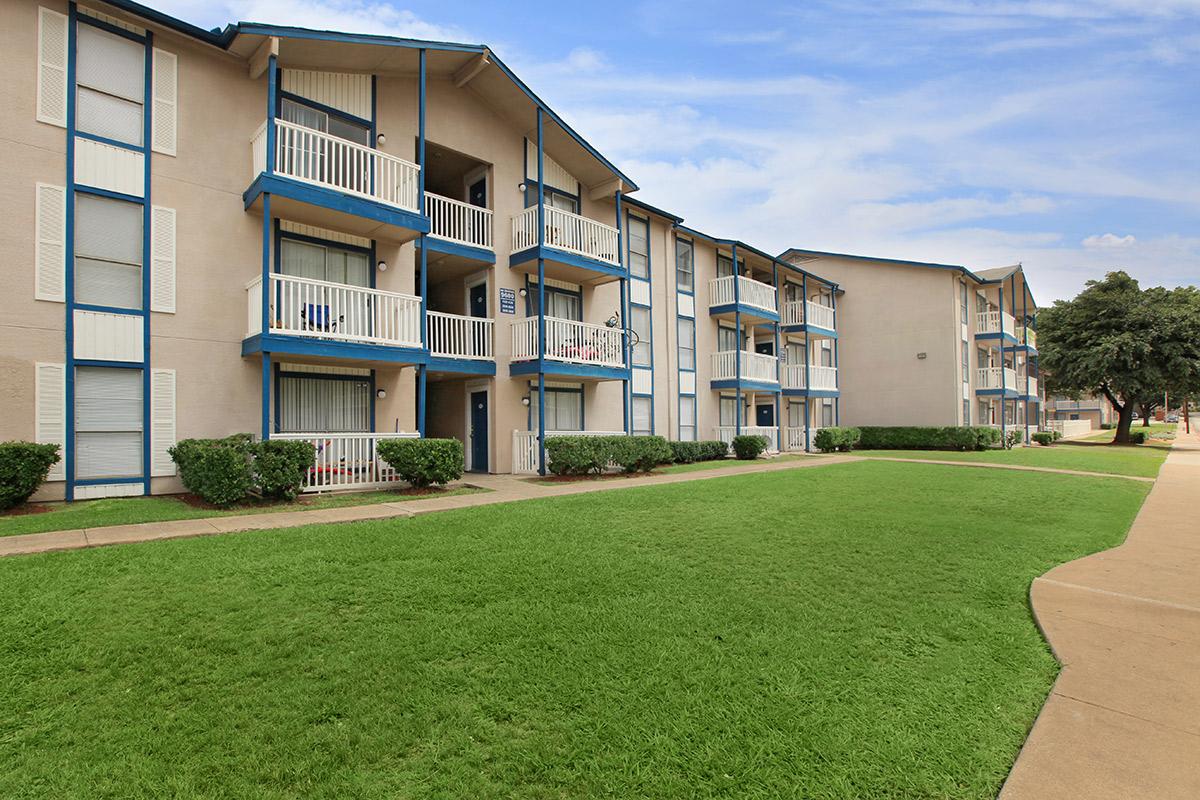 a large lawn in front of a brick building