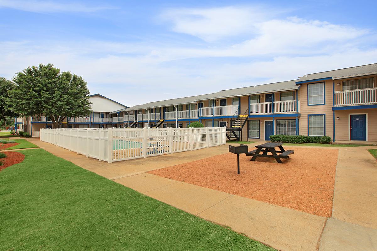 a large brick building with grass and trees