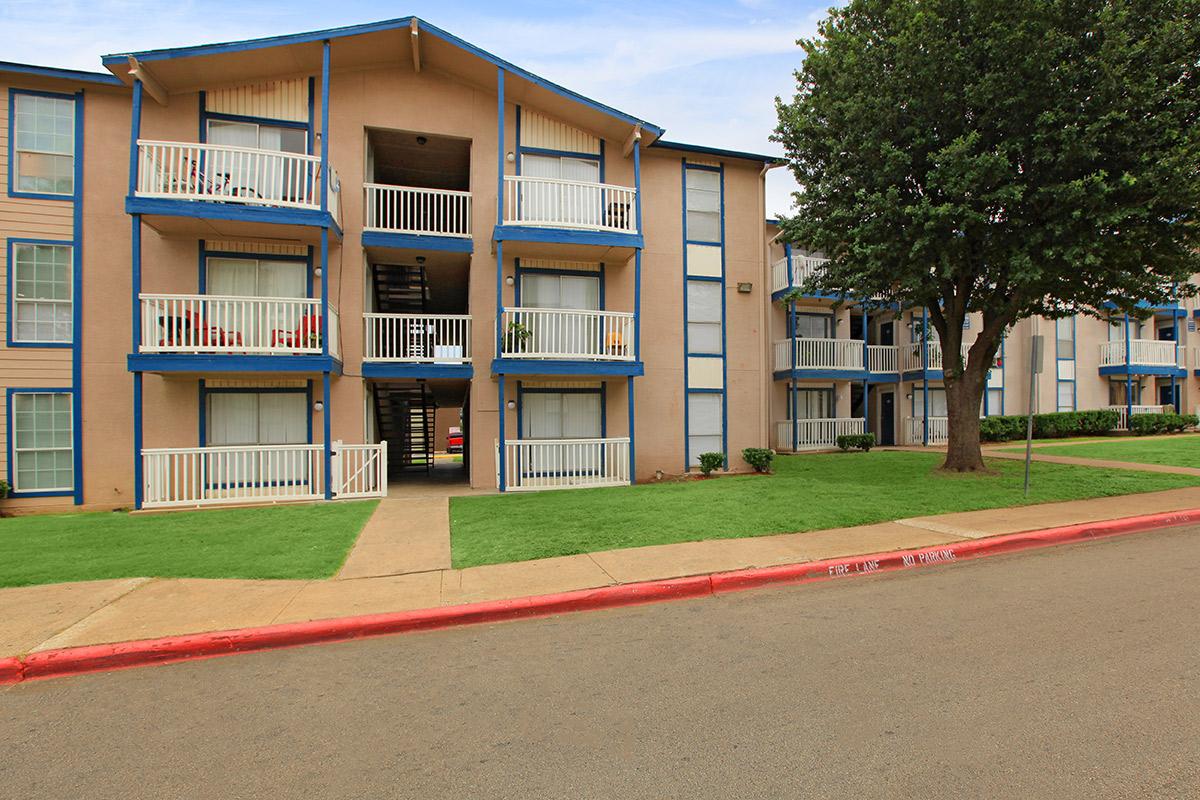 a large brick building with grass in front of a house