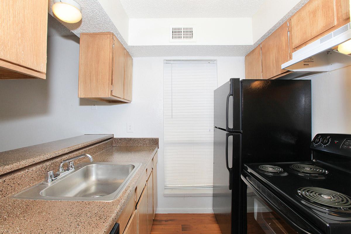 a modern kitchen with stainless steel appliances and wooden cabinets