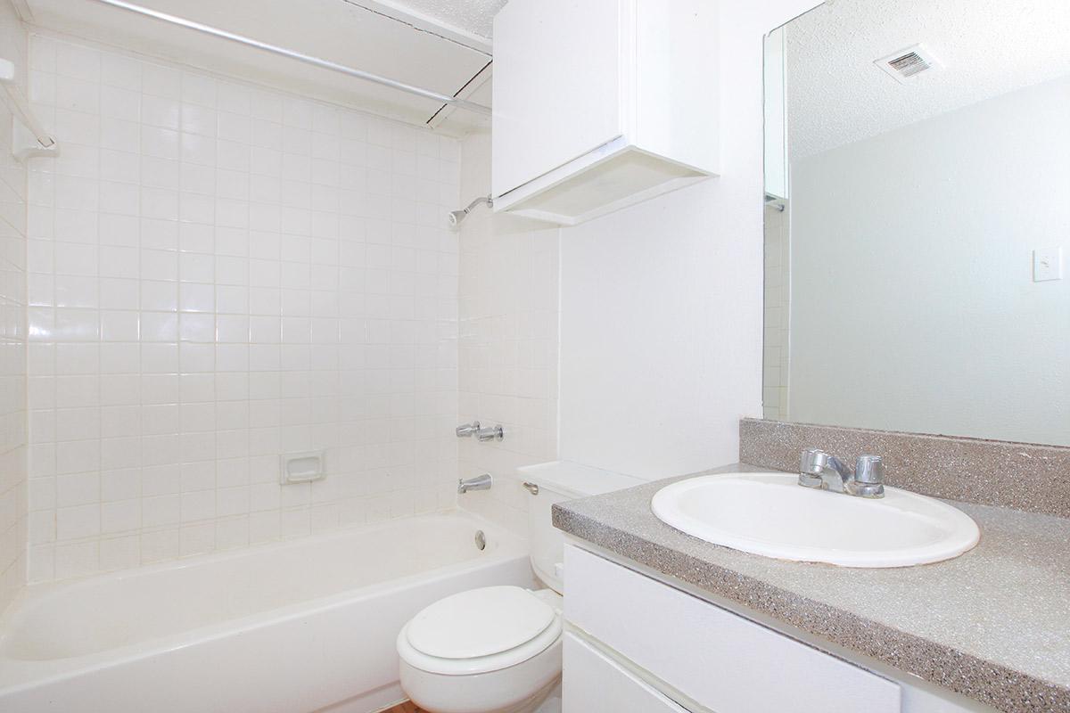 a white sink sitting next to a shower