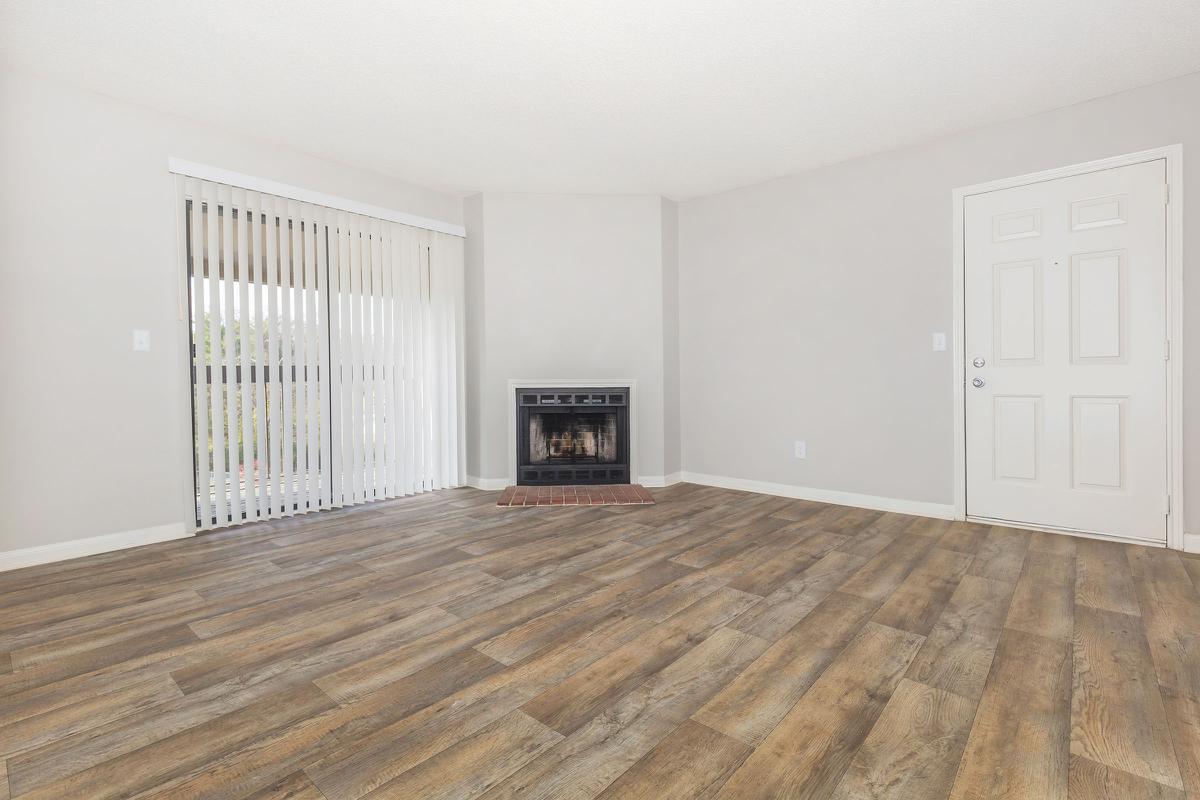 Vinyl wood floored living room with sliding door and fireplace in two bedroom apartment in Nashville, TN.