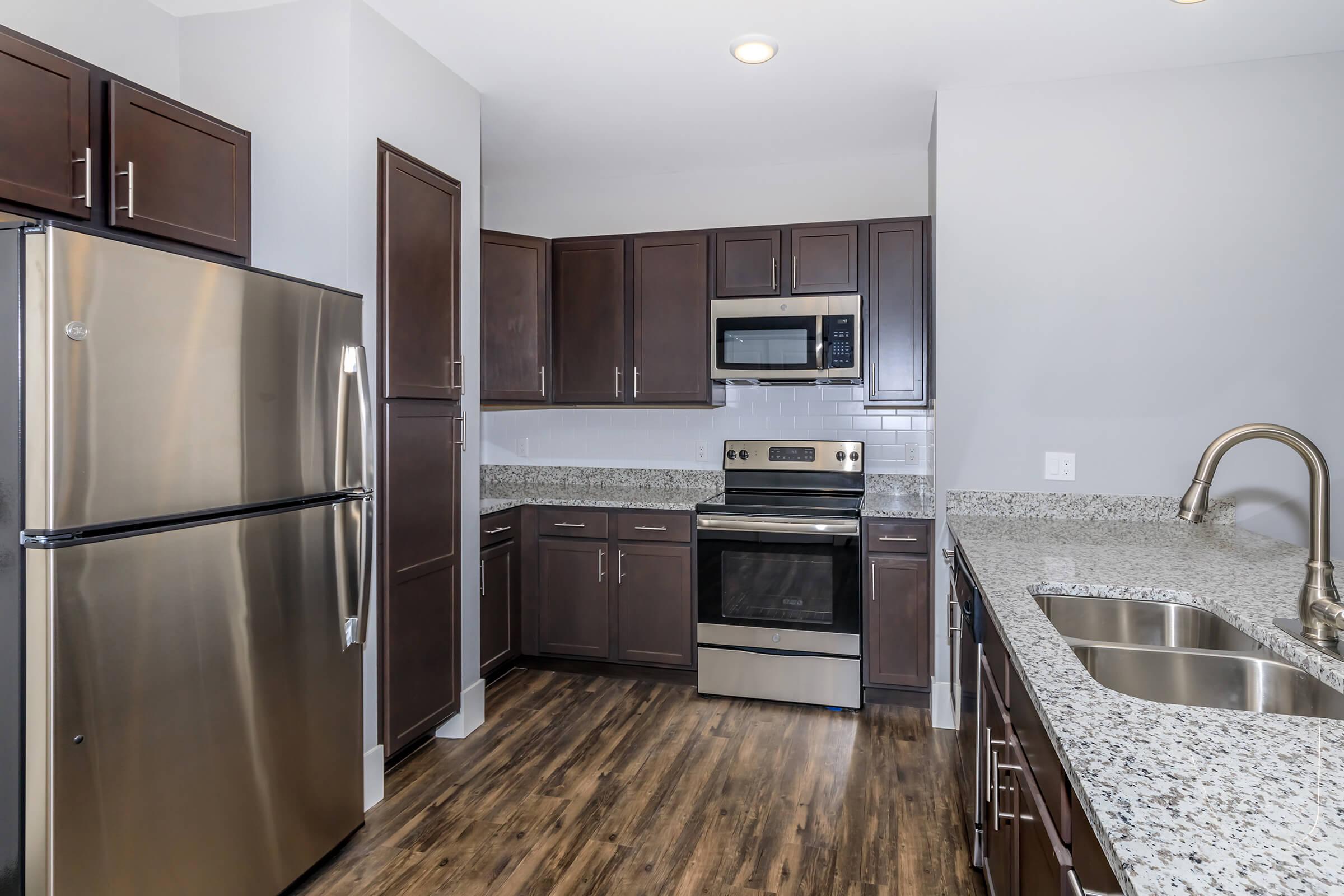 a modern kitchen with stainless steel appliances and wooden cabinets