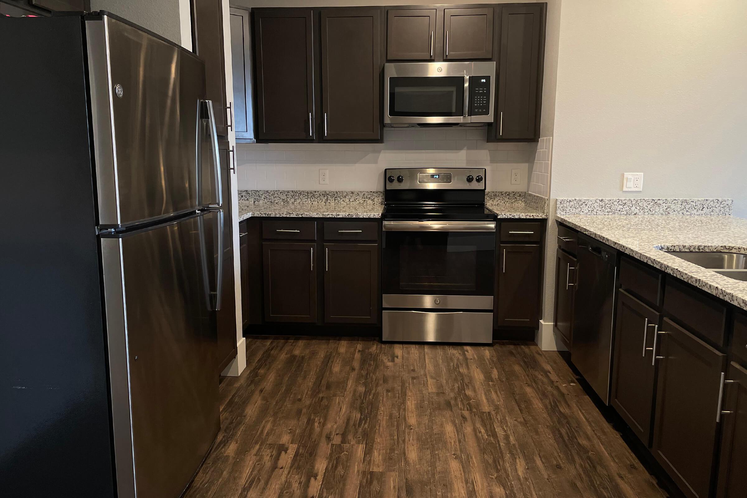 a large kitchen with stainless steel appliances and wooden cabinets