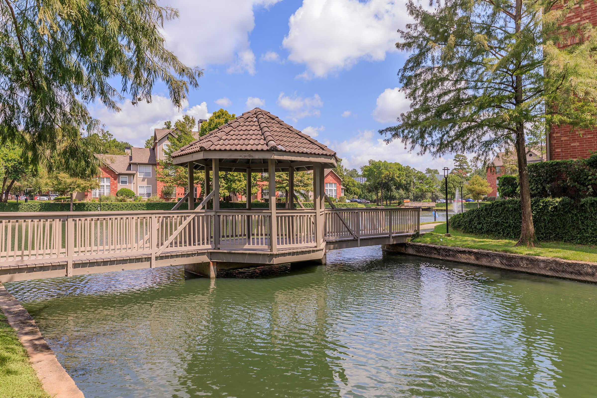 a bridge over a body of water surrounded by trees