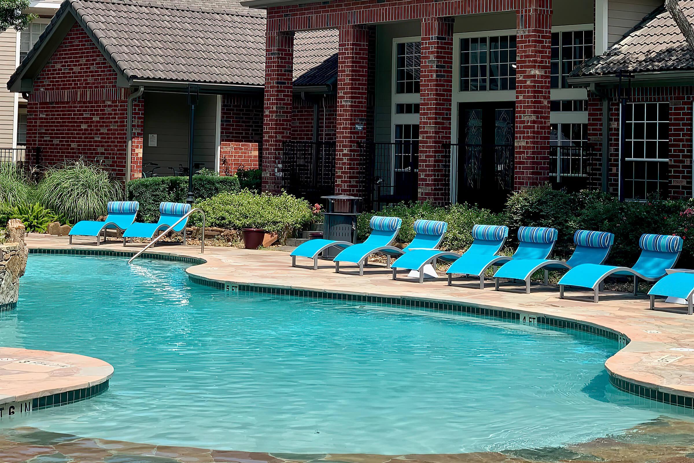 a group of lawn chairs sitting on top of a swimming pool