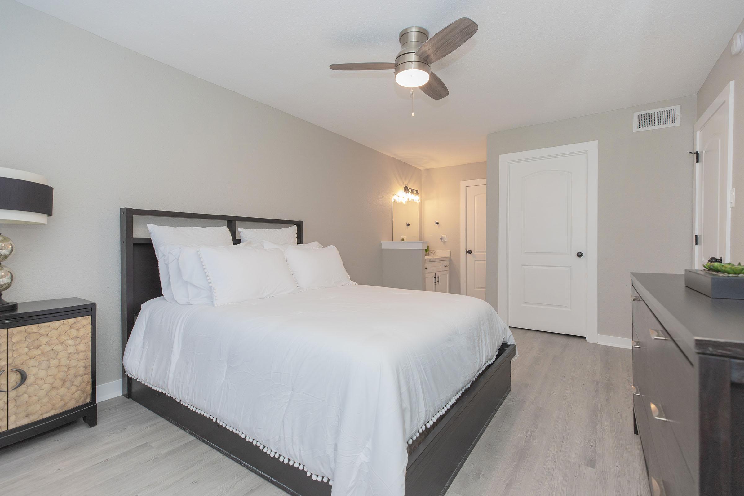 a bedroom with a bed and desk in a hotel room